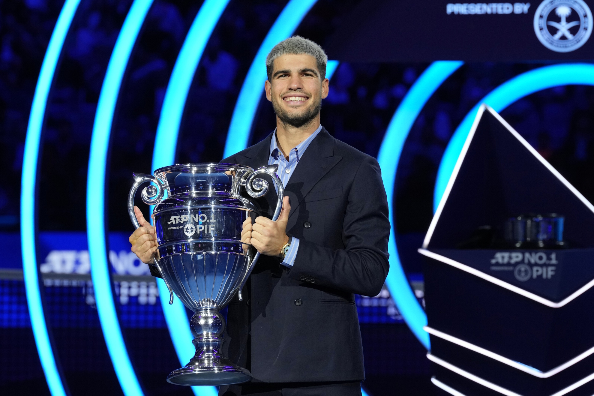 Spain's Carlos Alcaraz holds the trophy for finishing the year ranked No. 1.