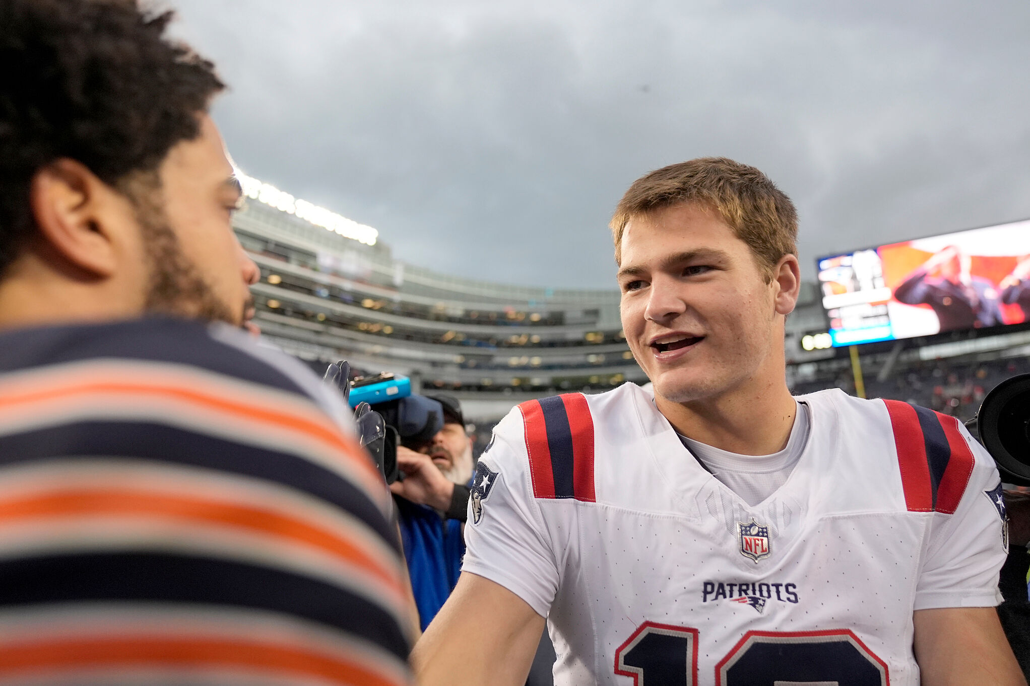 New England Patriots quarterback Drake Maye, right, and Chicago Bears quarterback Caleb Williams meet after the Patriots' win over the Bears