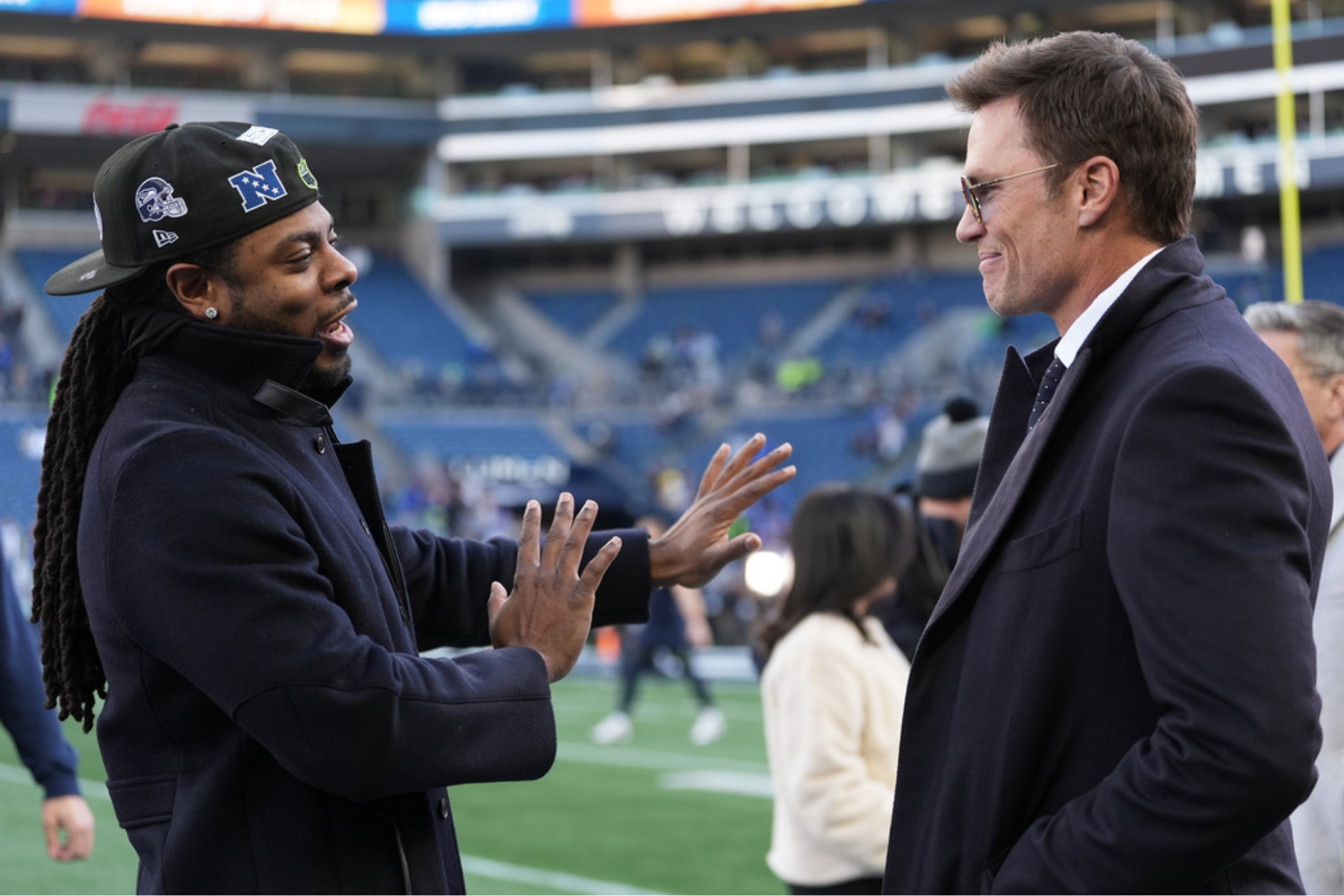 Former NFL players Richard Sherman, left, and Tom Brady talk