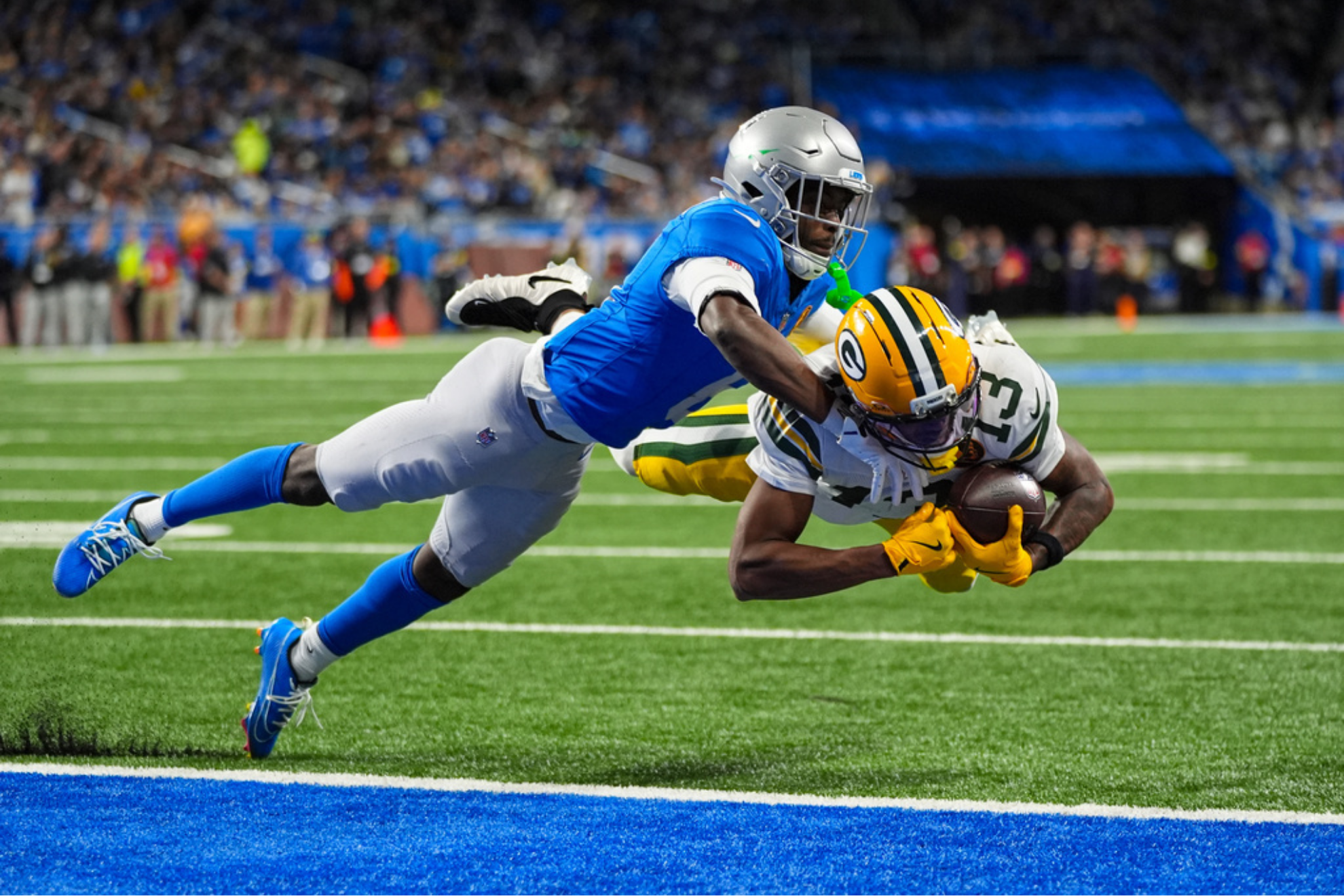 Green Bay Packers wide receiver Dontayvion Wicks dives in for a touchdown under Detroit Lions cornerback Terrion Arnold