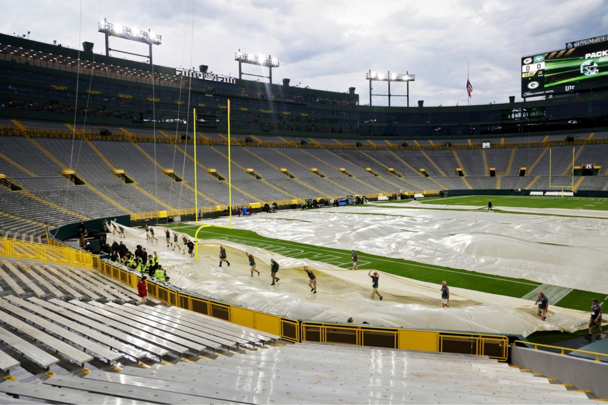Workers uncover the field at Lambeau Field