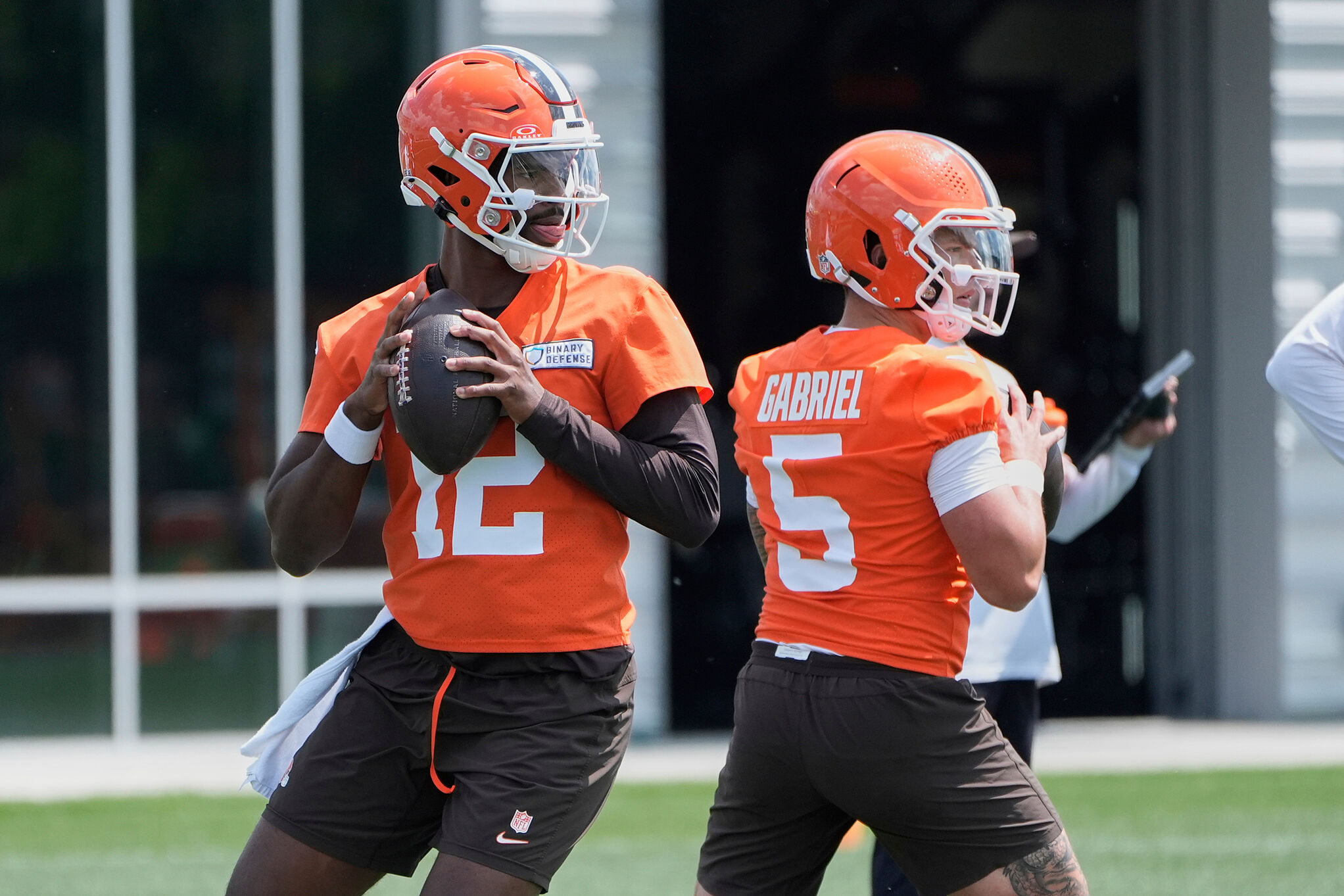 Cleveland Browns quarterback Shedeur Sanders (12) and quarterback Dillon Gabriel (5) throw during practice at NFL football minicamp in Berea, Ohio