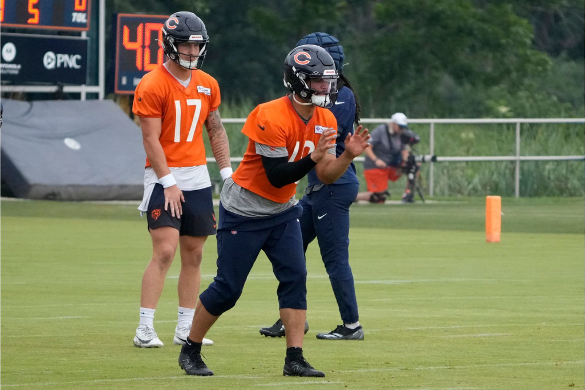 Chicago Bears quarterback Caleb Williams practices as quarterback Tyson Bagent stands behind him