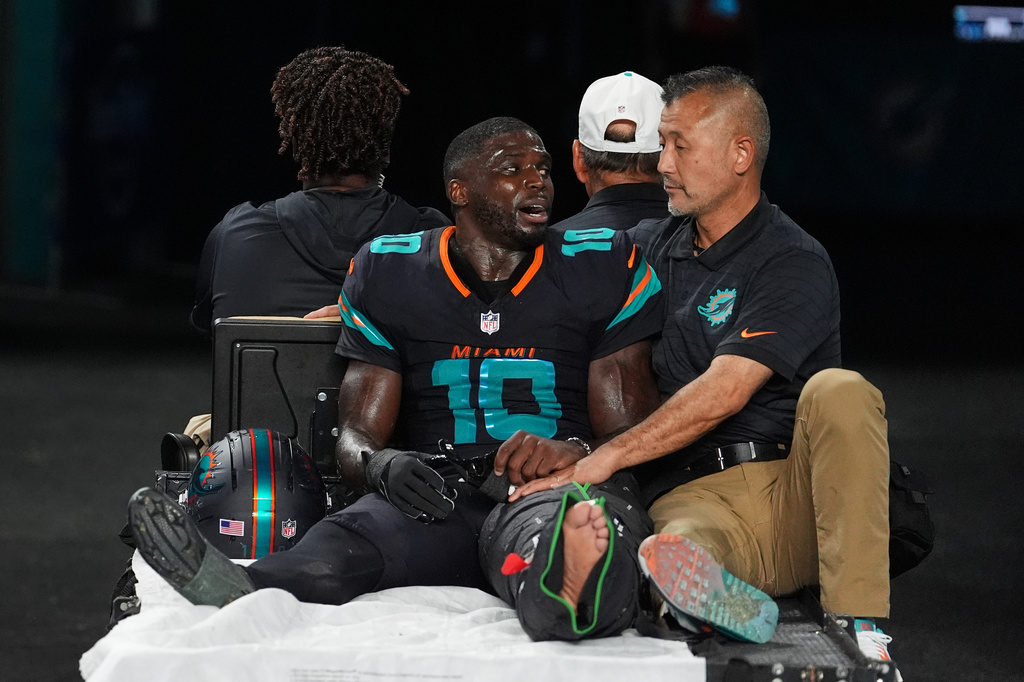 Miami Dolphins wide receiver Tyreek Hill (10) talks with a staff member as he is carted off the field after suffering an unknown lower leg injury in the second half of an NFL football game against the New York Jets, Monday, Sept. 29, 2025, in Miami Gardens, Fla.