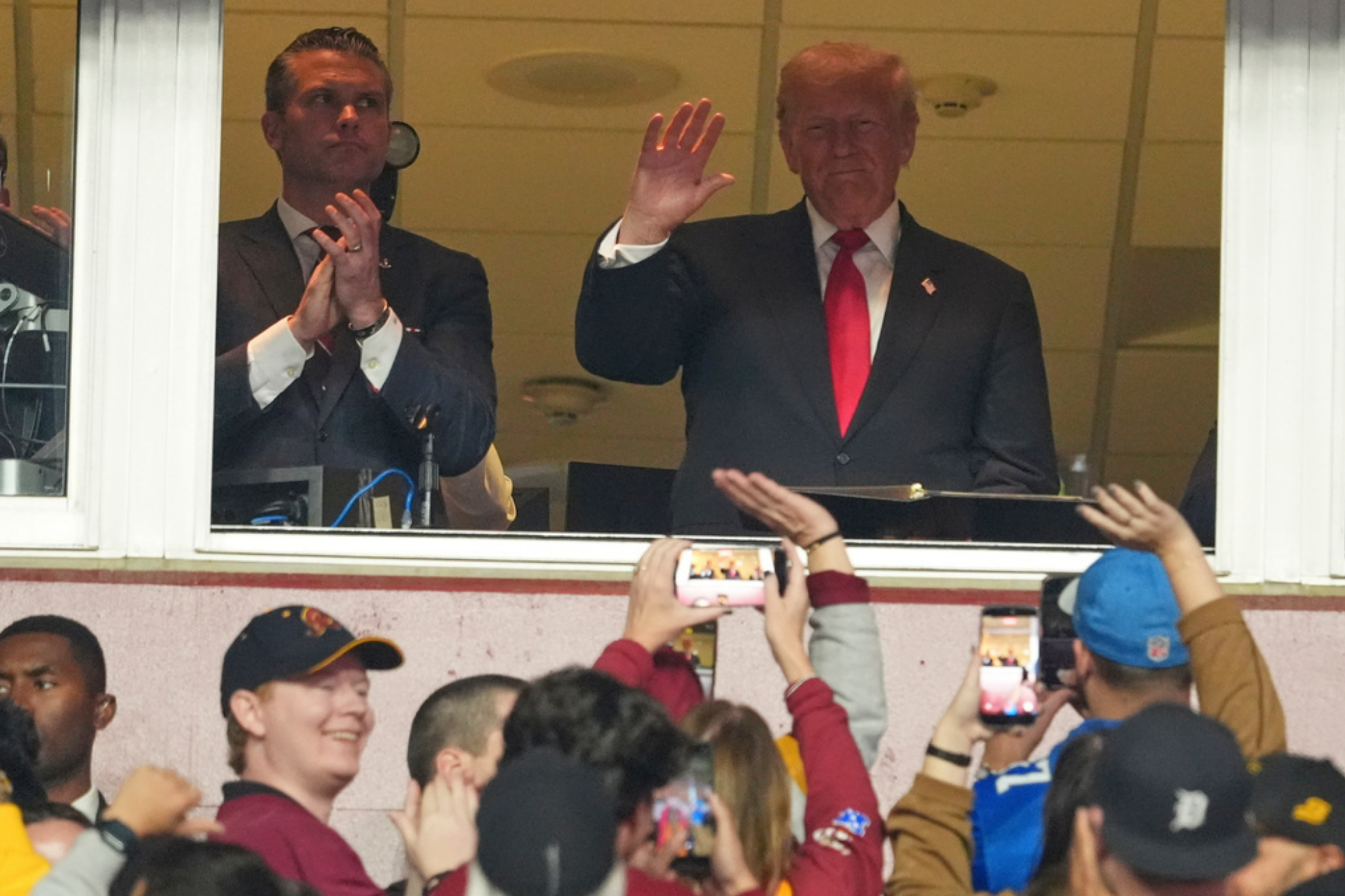 President Donald Trump, right, and Defense Secretary Pete Hegseth attend an NFL football game between the Washington Commanders and the Detroit Lions