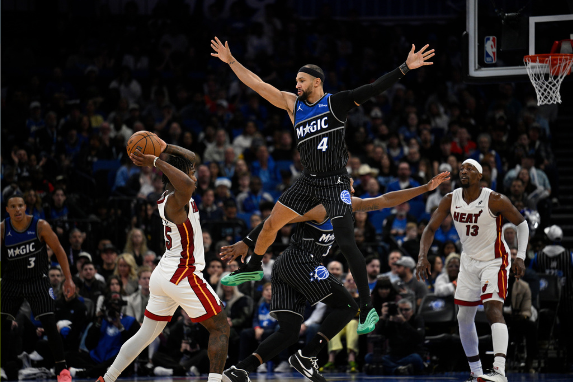 Orlando Magic guard Jalen Suggs (4) defends as Miami Heat guard Davion Mitchell