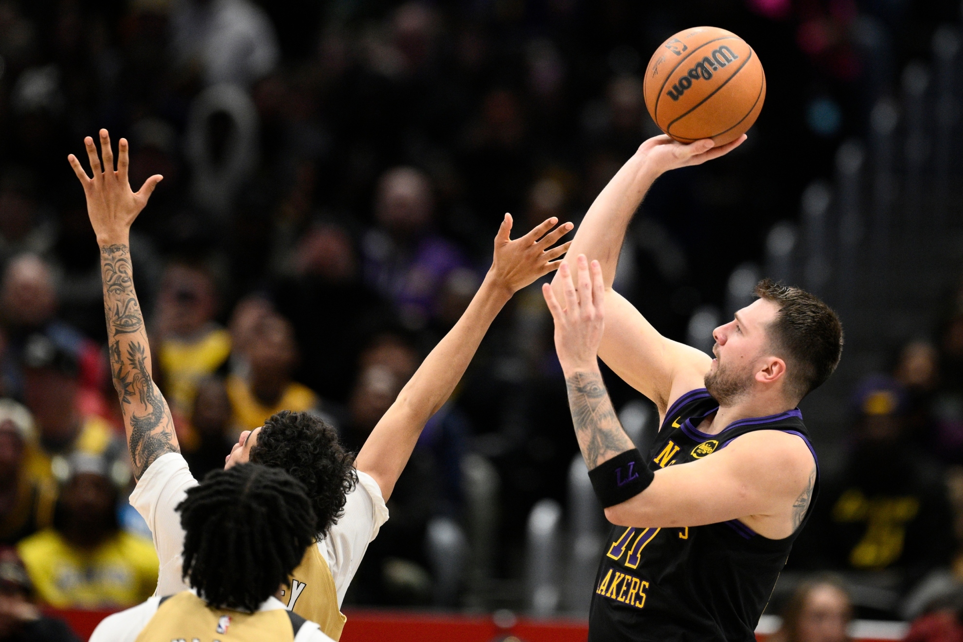 Luka Doncic, right, looks to shoot during the first half of an NBA basketball game against the Wizards.