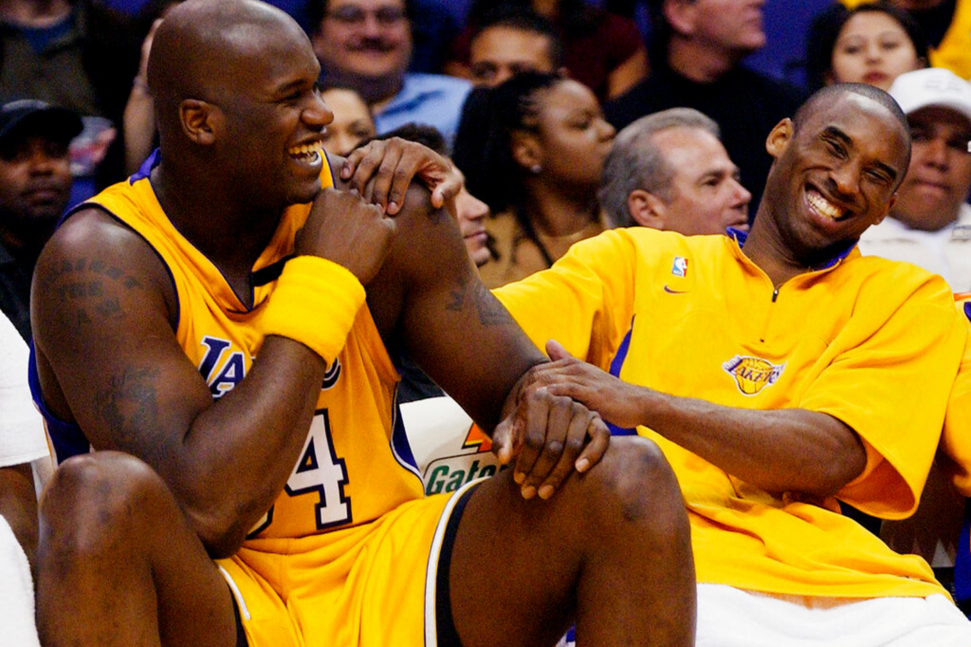 Former Los Angeles Lakers Shaquille O'Neal, left, and Kobe Bryant share a laugh on the bench
