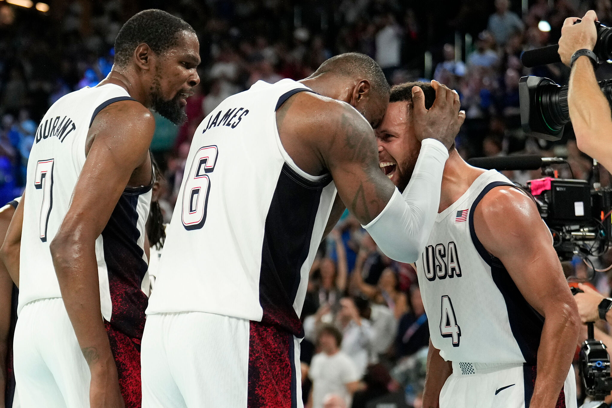 United States' Kevin Durant (7), LeBron James (6) and Steph Curry (4) celebrate after beating Serbia during the semifinals at the 2024 Summer Olympics