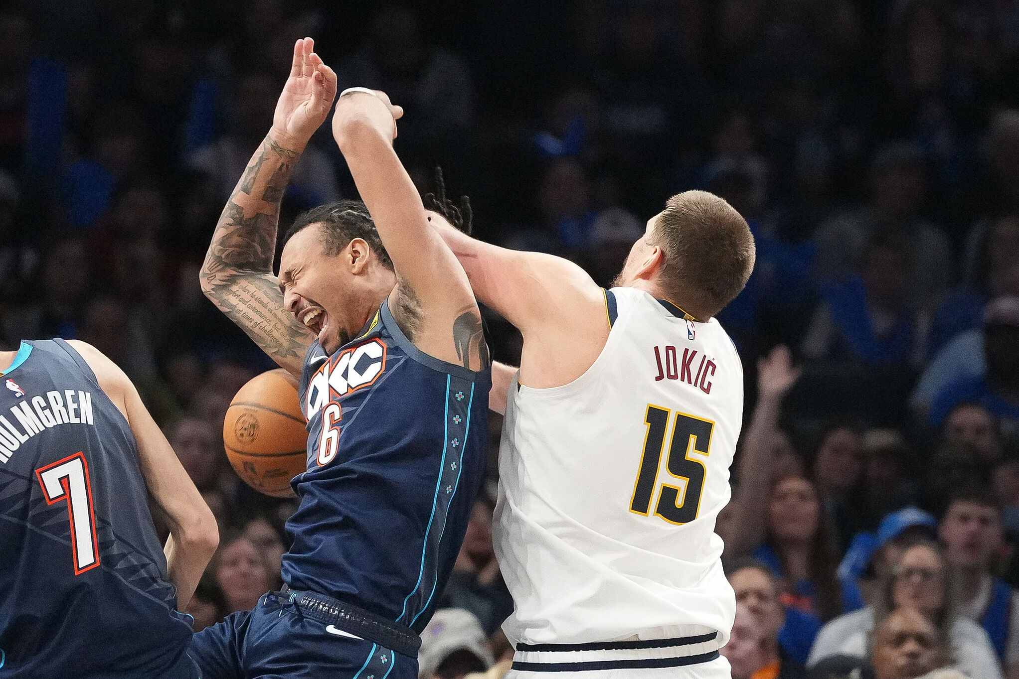 Oklahoma City Thunder forward Jaylin Williams (6) falls into Denver Nuggets center Nikola Jokic (15) as he goes after a rebound during the second half of an NBA basketball
