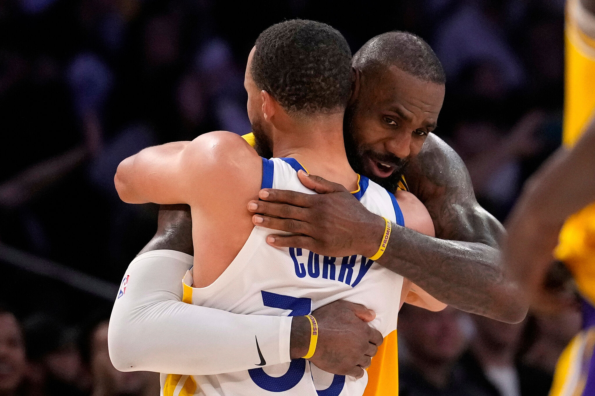 Golden State Warriors guard Stephen Curry, left, and Los Angeles Lakers forward LeBron James hug after the Warriors defeated the Lakers