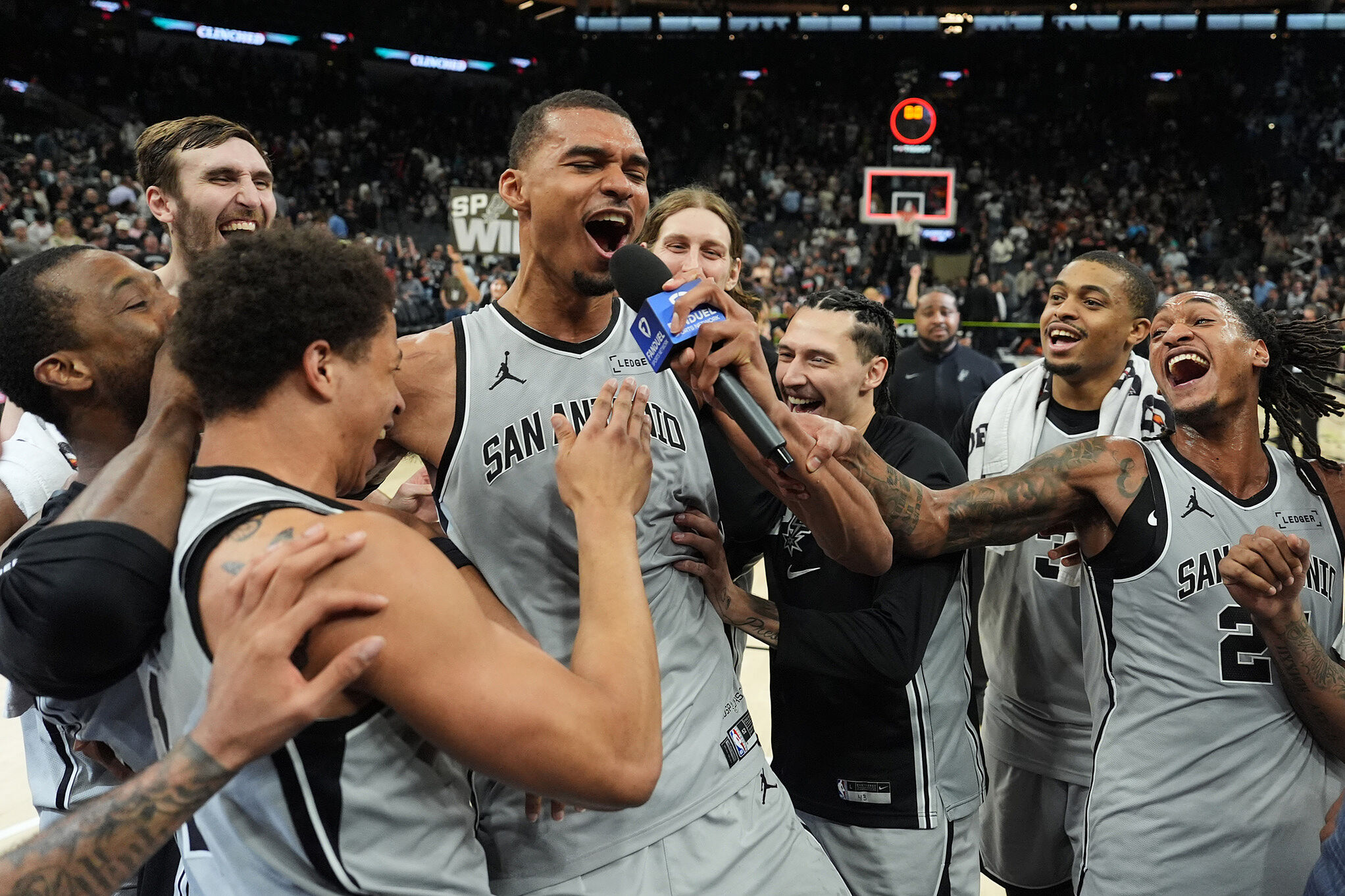 San Antonio Spurs forward Victor Wembanyama, center, celebrates with teammates after he hit a game-winning score against the Phoenix Suns