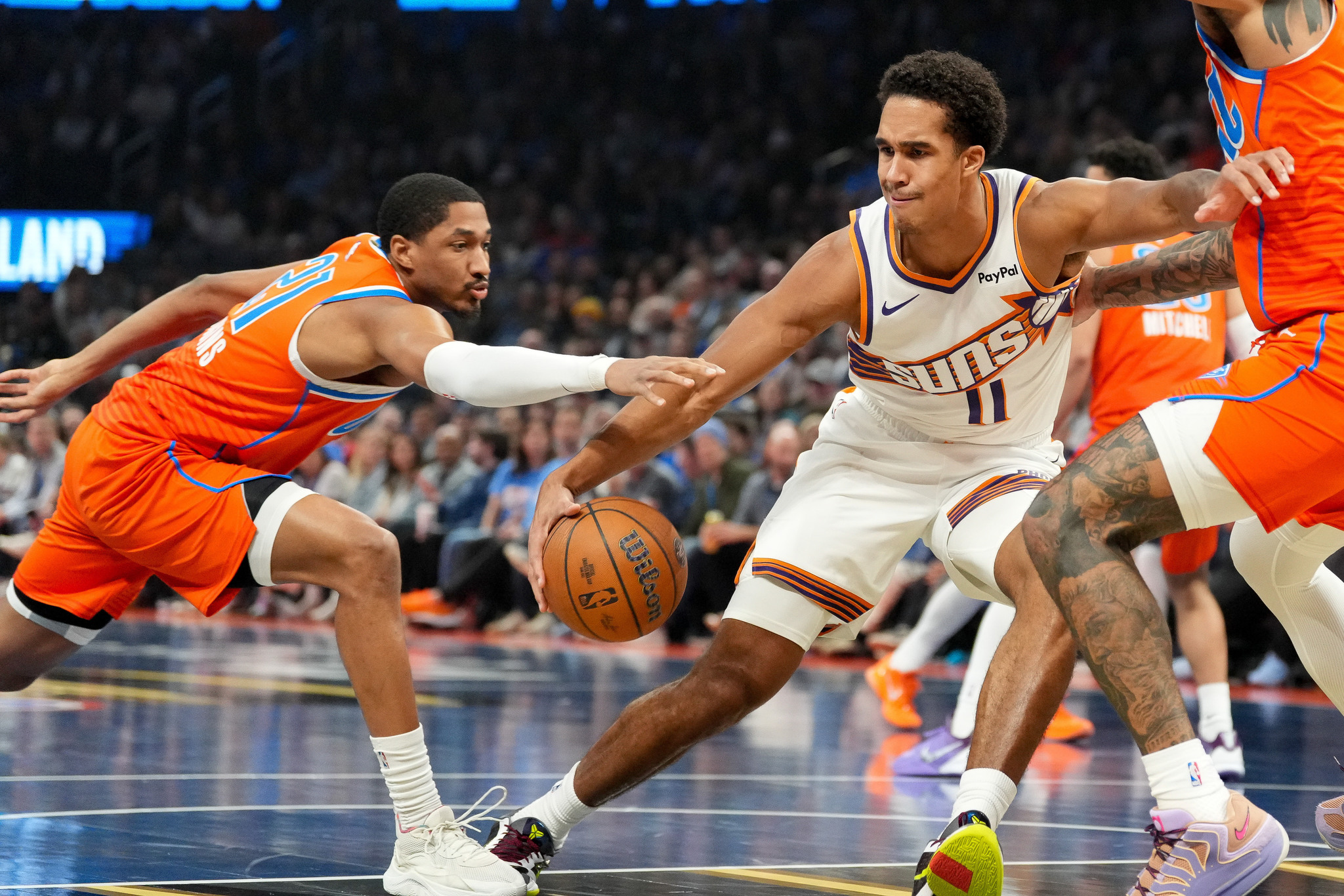Phoenix Suns forward , right, tries to keep the ball away from Oklahoma City Thunder guard Aaron Wiggins