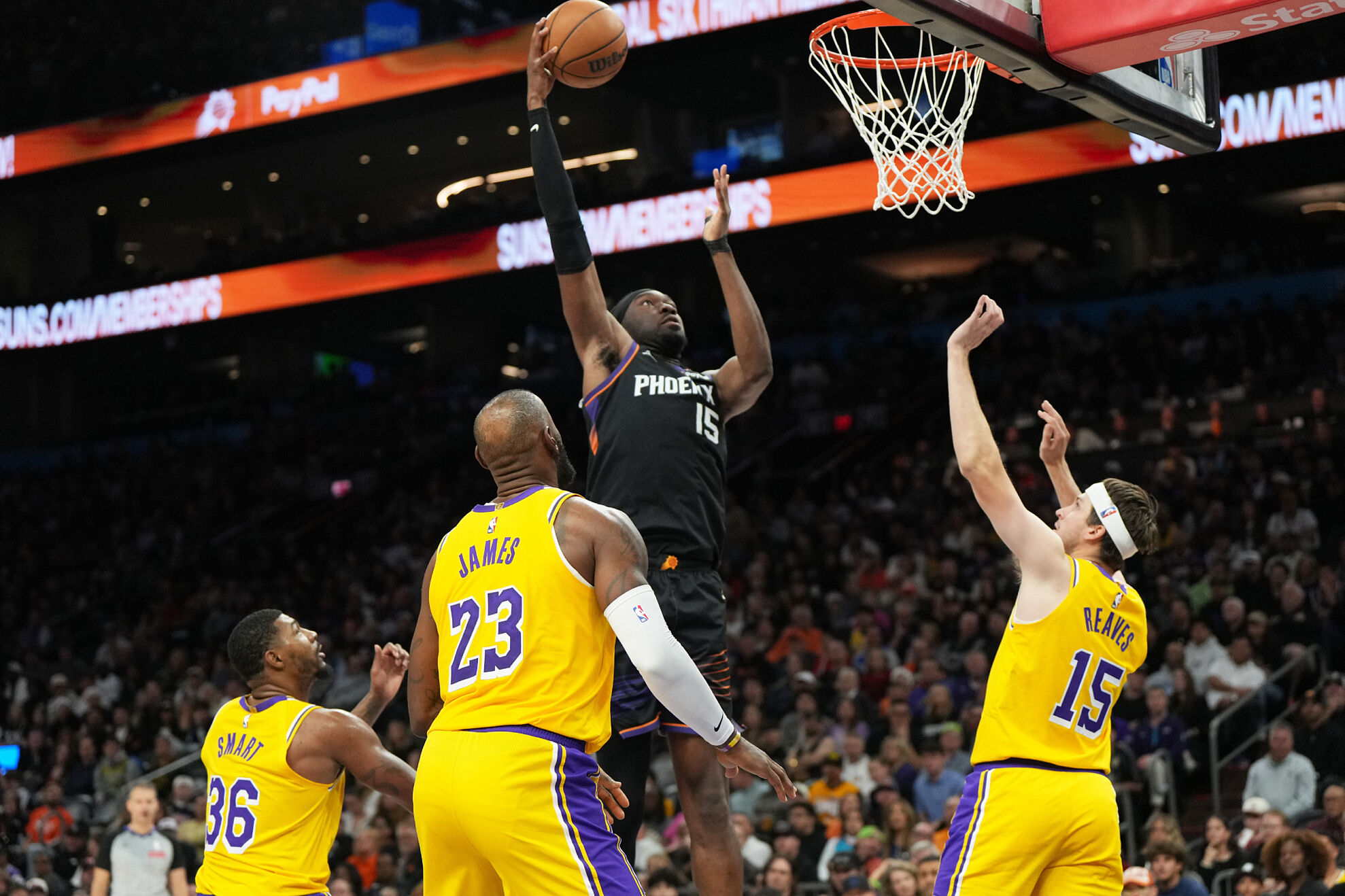 Phoenix Suns center Mark Williams scores between Los Angeles Lakers guard Marcus Smart (36), forward Lebron James (23), and guard Austin Reaves during the second half of an NBA basketball game, Tuesday, Dec. 23, 2025, in Phoenix.