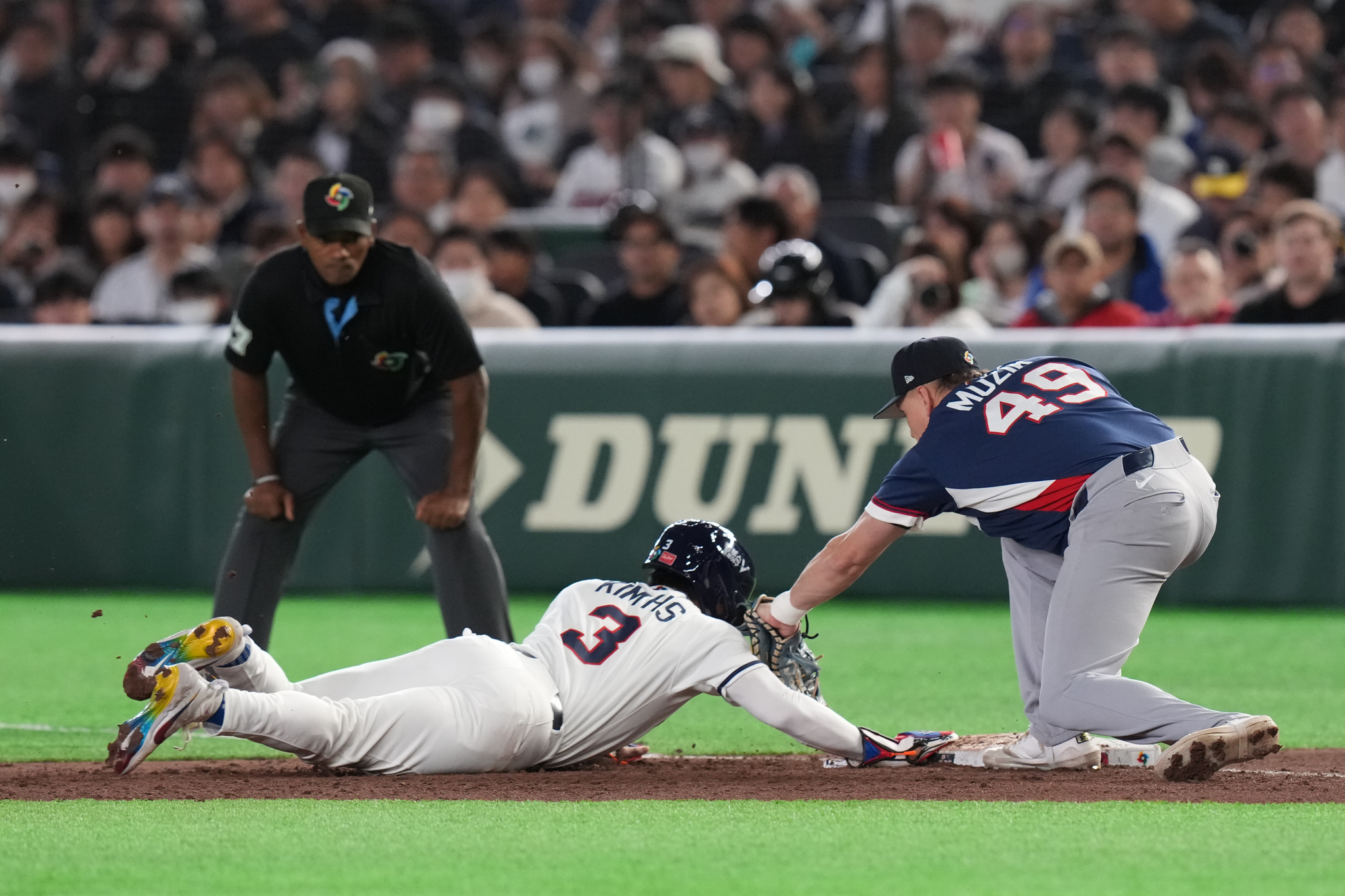 South Korea's Kim Hyeseong, center, slides to first base against Czech Republic's Martin Muzik, right, during the fifth inning