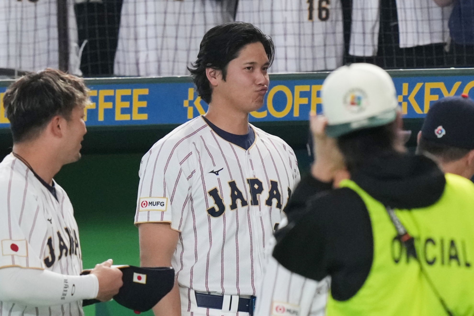 Japan's Shohei Ohtani reacts as he walks wits his teammates.