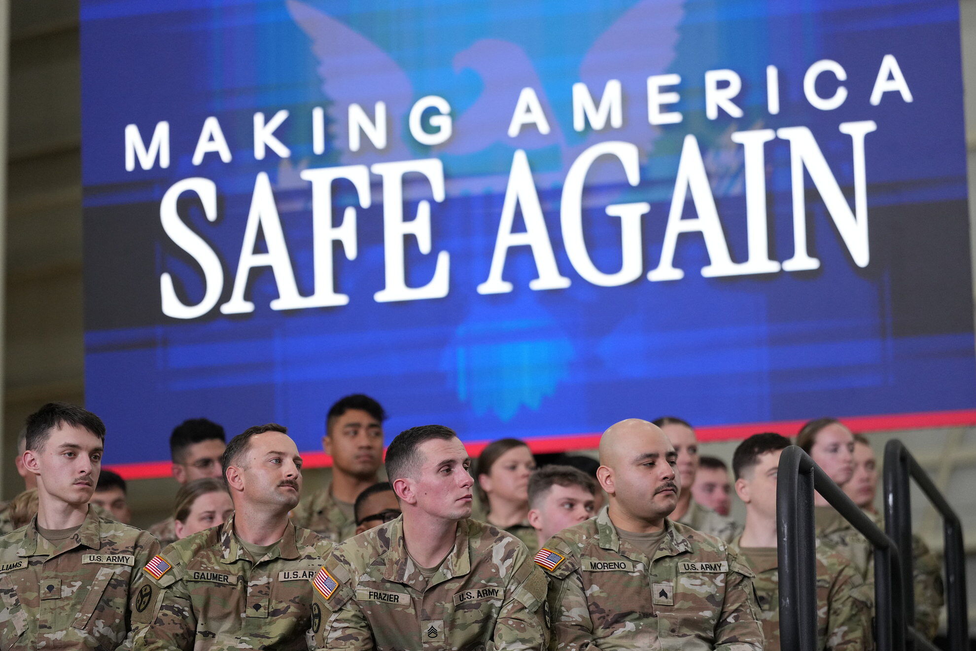 U.S. Army Soldiers on stage, look at President Trump in a roundtable discussion on public safety at a Tennessee Air National Guard Base