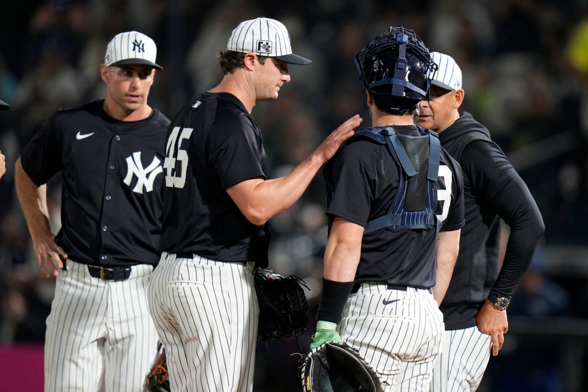 New York Yankees pitcher Gerrit Cole (45) taps catcher Austin Wells on the arm as Cole is taken out.