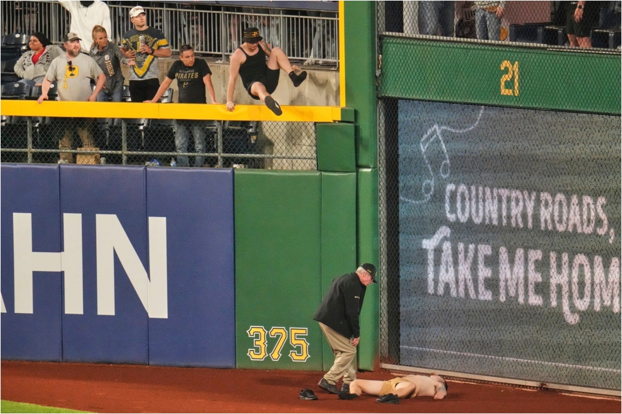 A fan lies on the warning track in right field of PNC Park after falling out of the stands.
