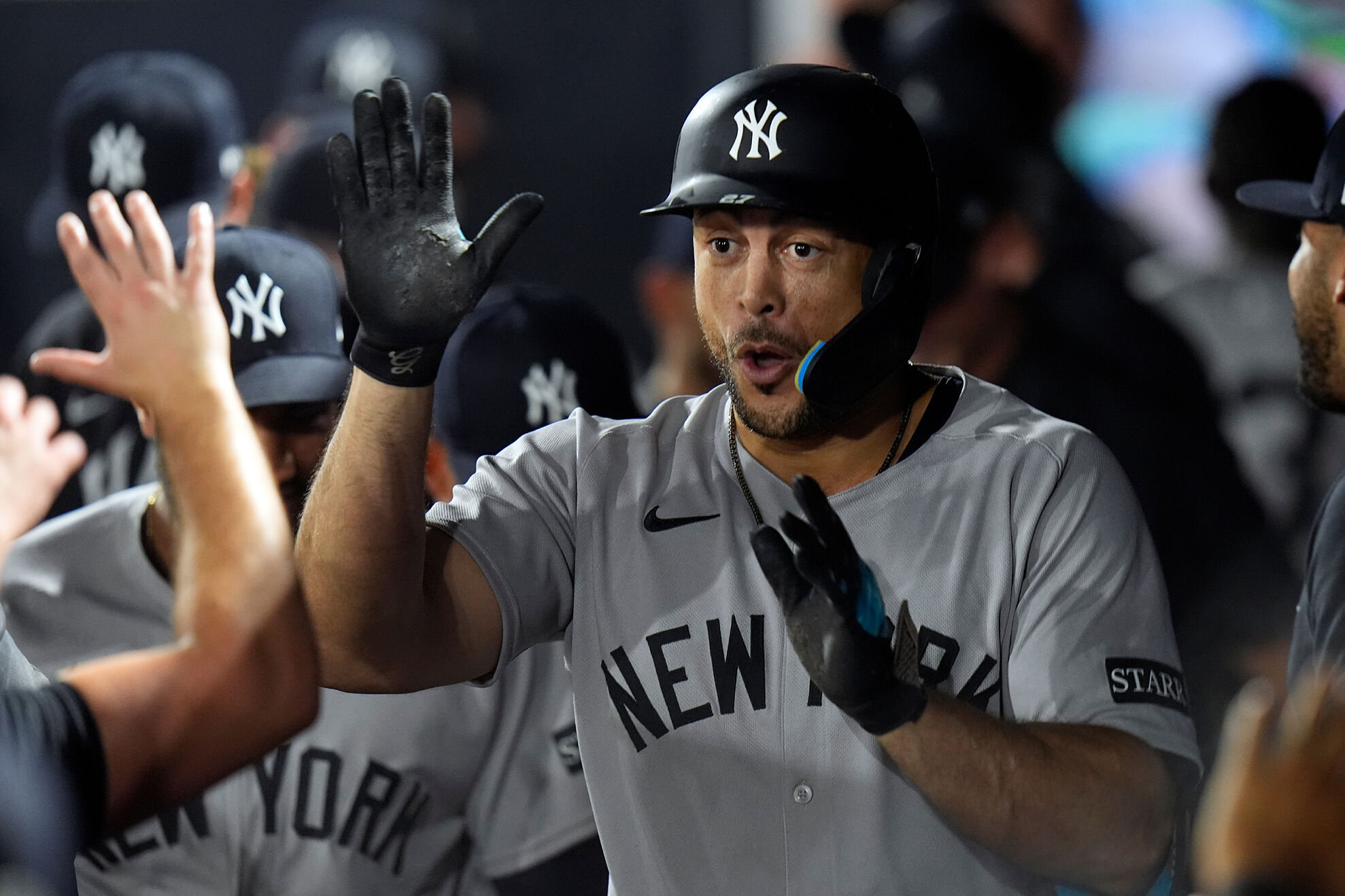 New York Yankees' Giancarlo Stanton celebrates in the dugout after hitting a solo home run off Tampa Bay Rays pitcher Shane Baz during the first inning of a baseball game Tuesday, Aug. 19, 2025, in Tampa, Fla.