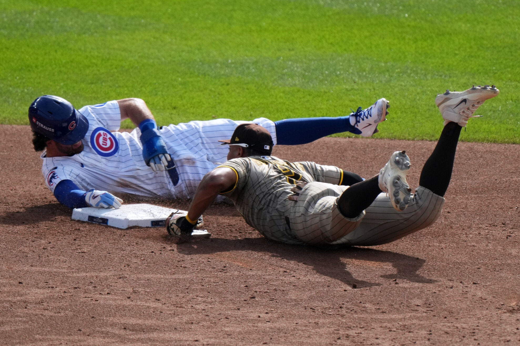 Chicago Cubs' Dansby Swanson slides safely back to second with San Diego Padres' Xander Bogaerts covering during the third inning of Game 2 of a National League wild card baseball game Wednesday, Oct. 1, 2025, in Chicago.