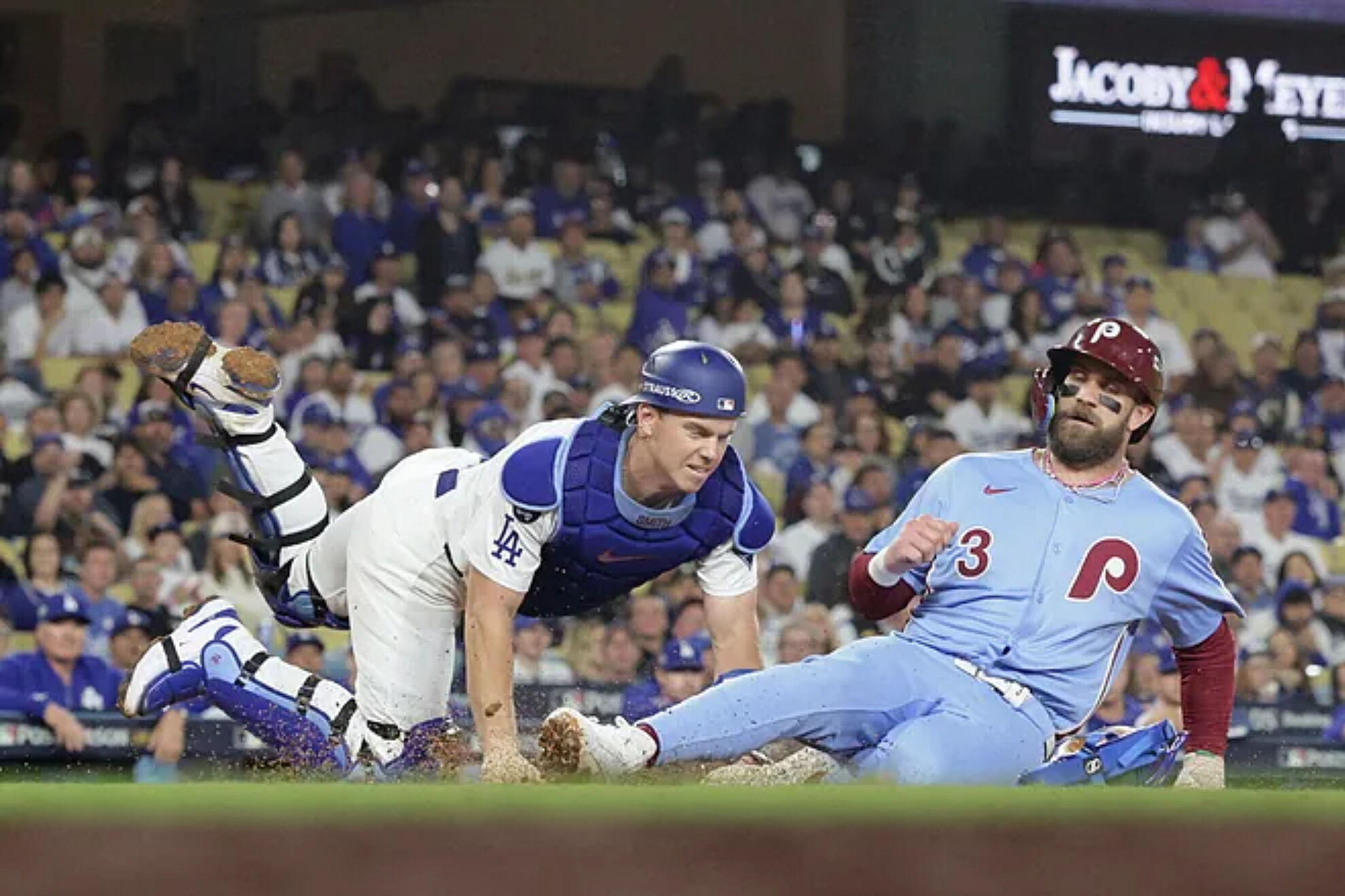 Bryce Harper (R) is tagged out at home plate by Los Angeles Dodgers Will Smith.