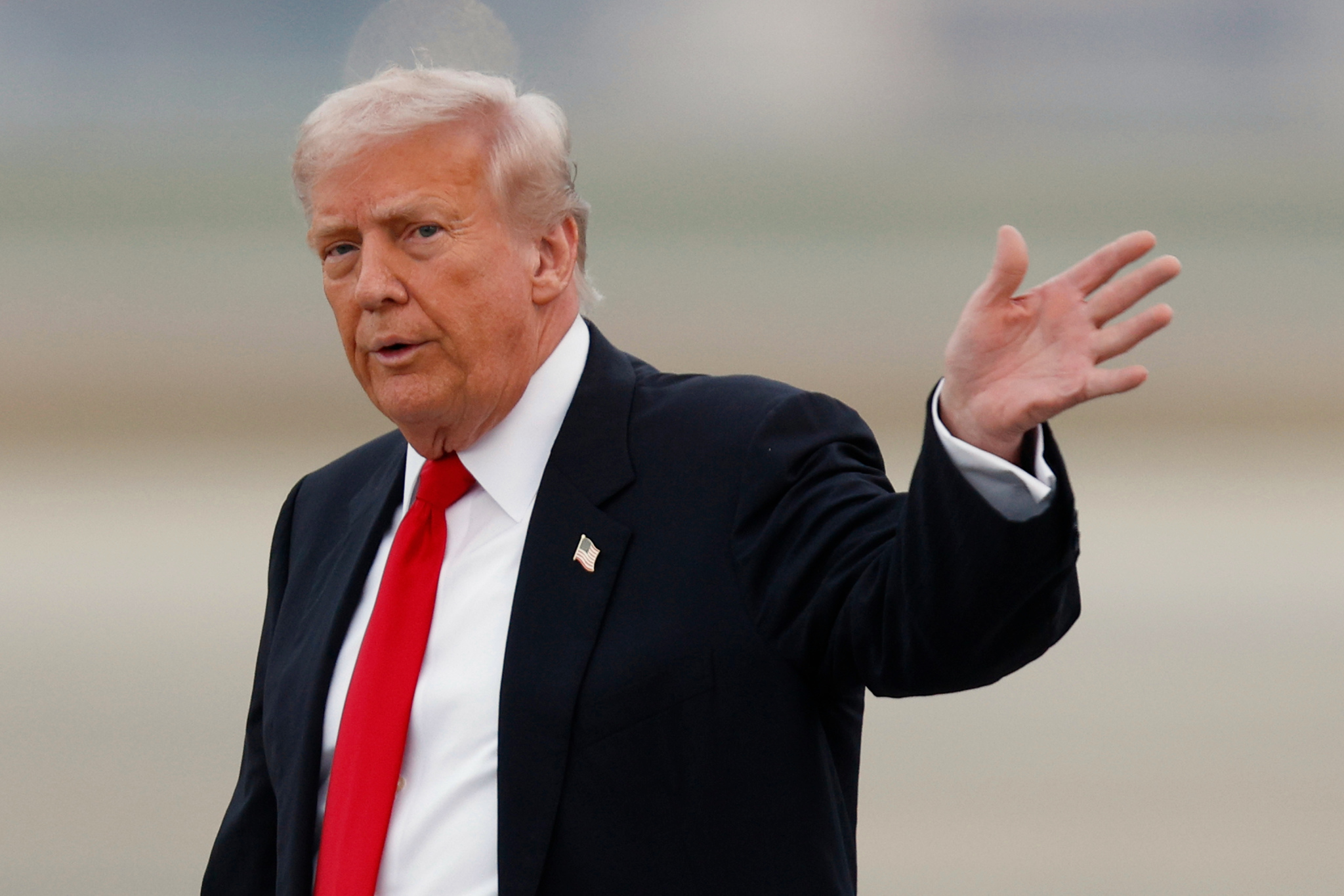 President Donald Trump waves before flying in to watch the Washington Commanders vs Detroit Lions