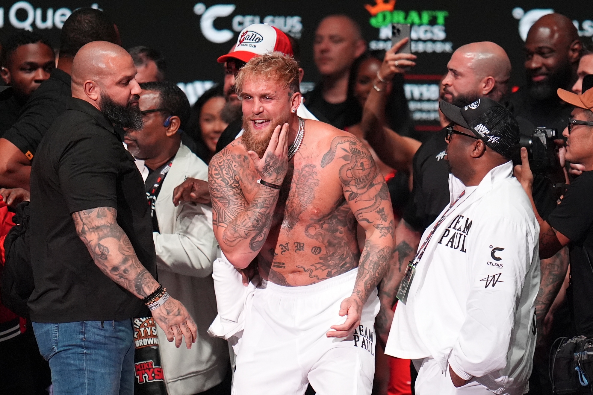 Jake Paul reacts after being slapped by Mike Tyson during a weigh-in ahead of their heavyweight fight.