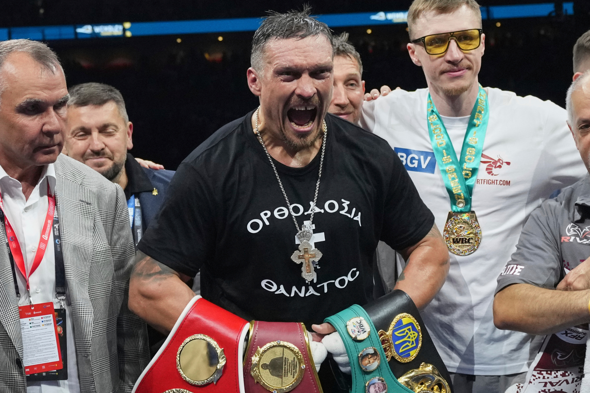Oleksandr Usyk celebrates with the heavyweight title belts after defeating Daniel Dubois.