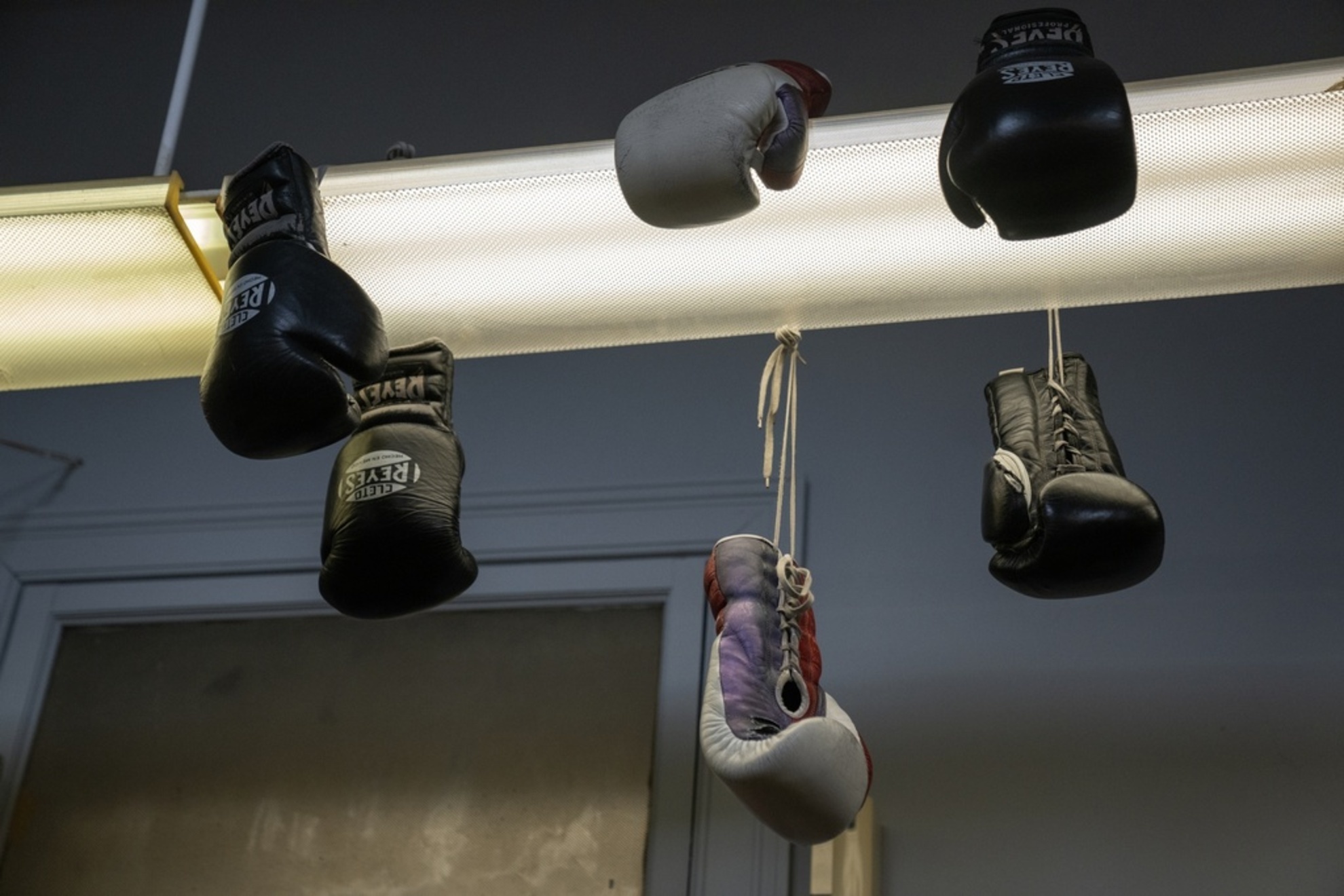 Gloves hang from fluorescent lights at Garfield Park Boxing