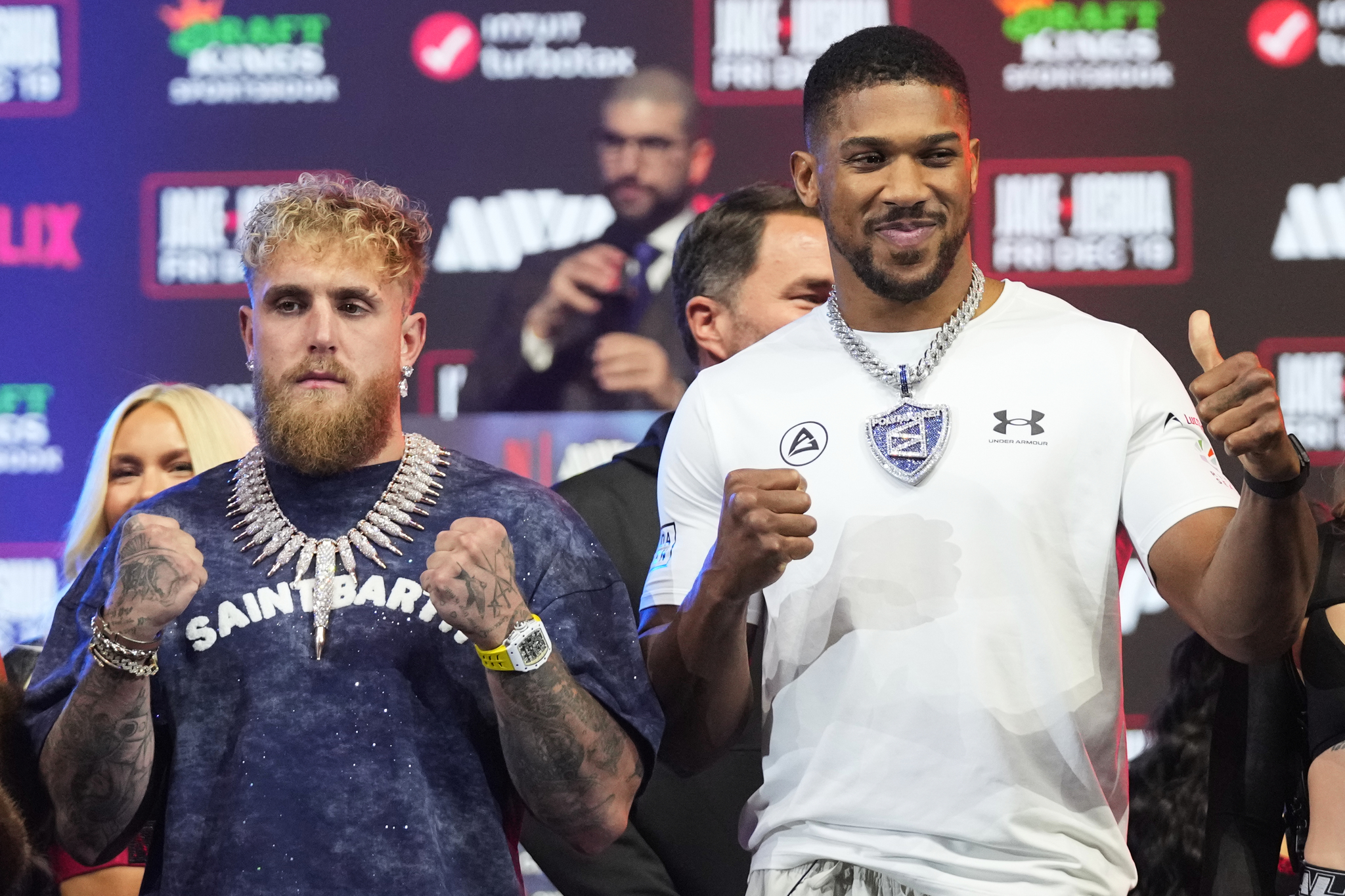 Jake Paul left, and Anthony Joshua face-off during a news conference promoting their upcoming heavyweight boxing match, Wednesday, Dec. 17, 2025, in Miami Beach