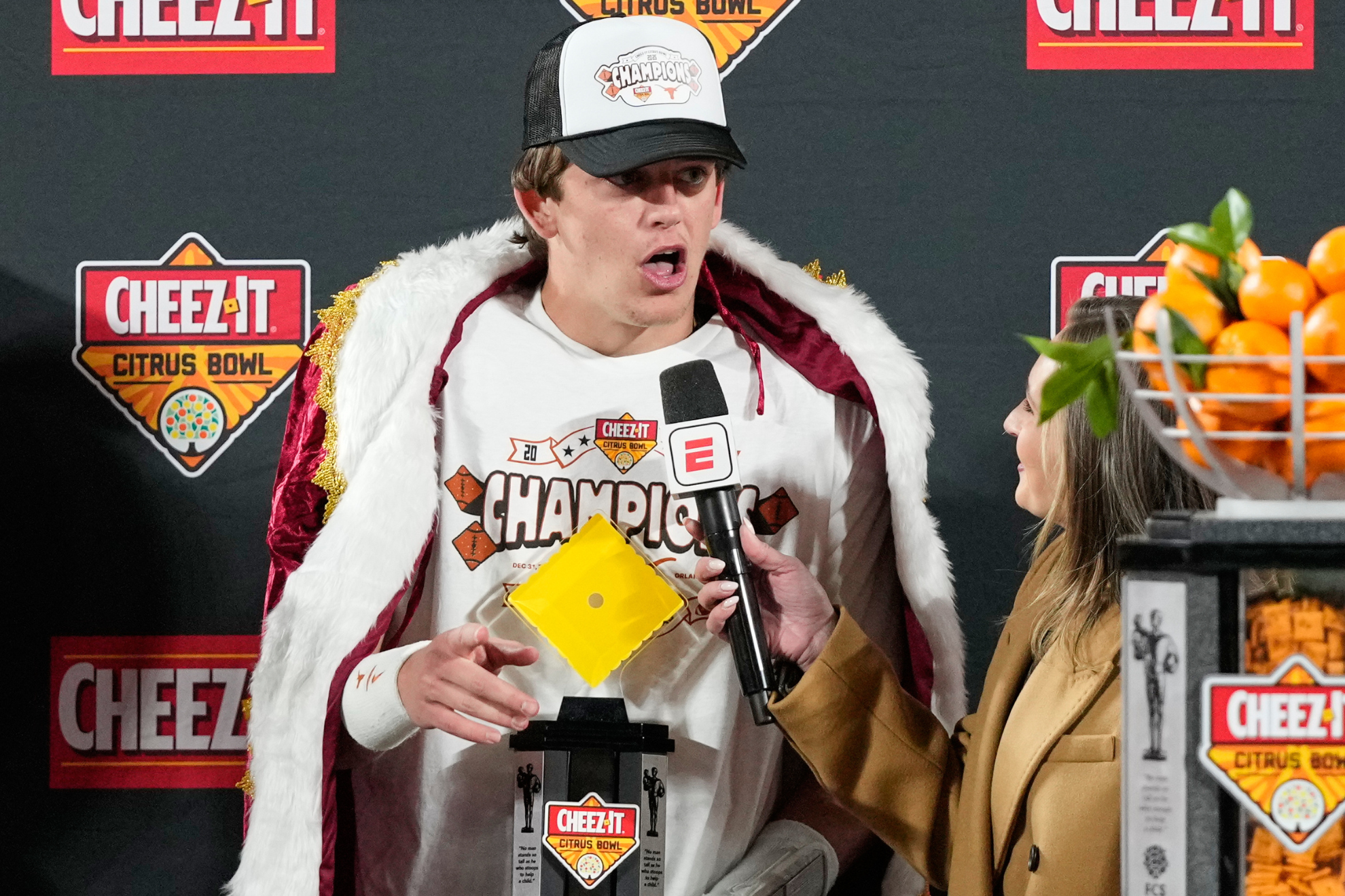 Texas Longhorns quarterback Arch Manning poses with the Citrus Bowl trophy after defeating the Michigan Wolverines.