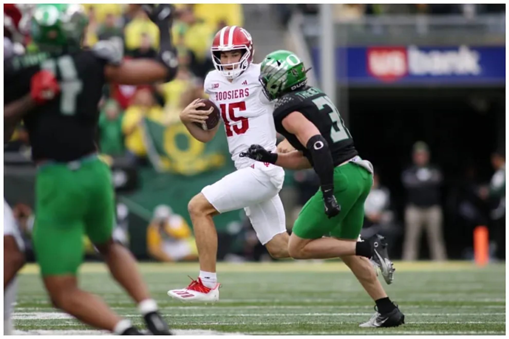 ernando Mendoza (15) runs the ball while defended by Oregon defensive back Dillon Thieneman