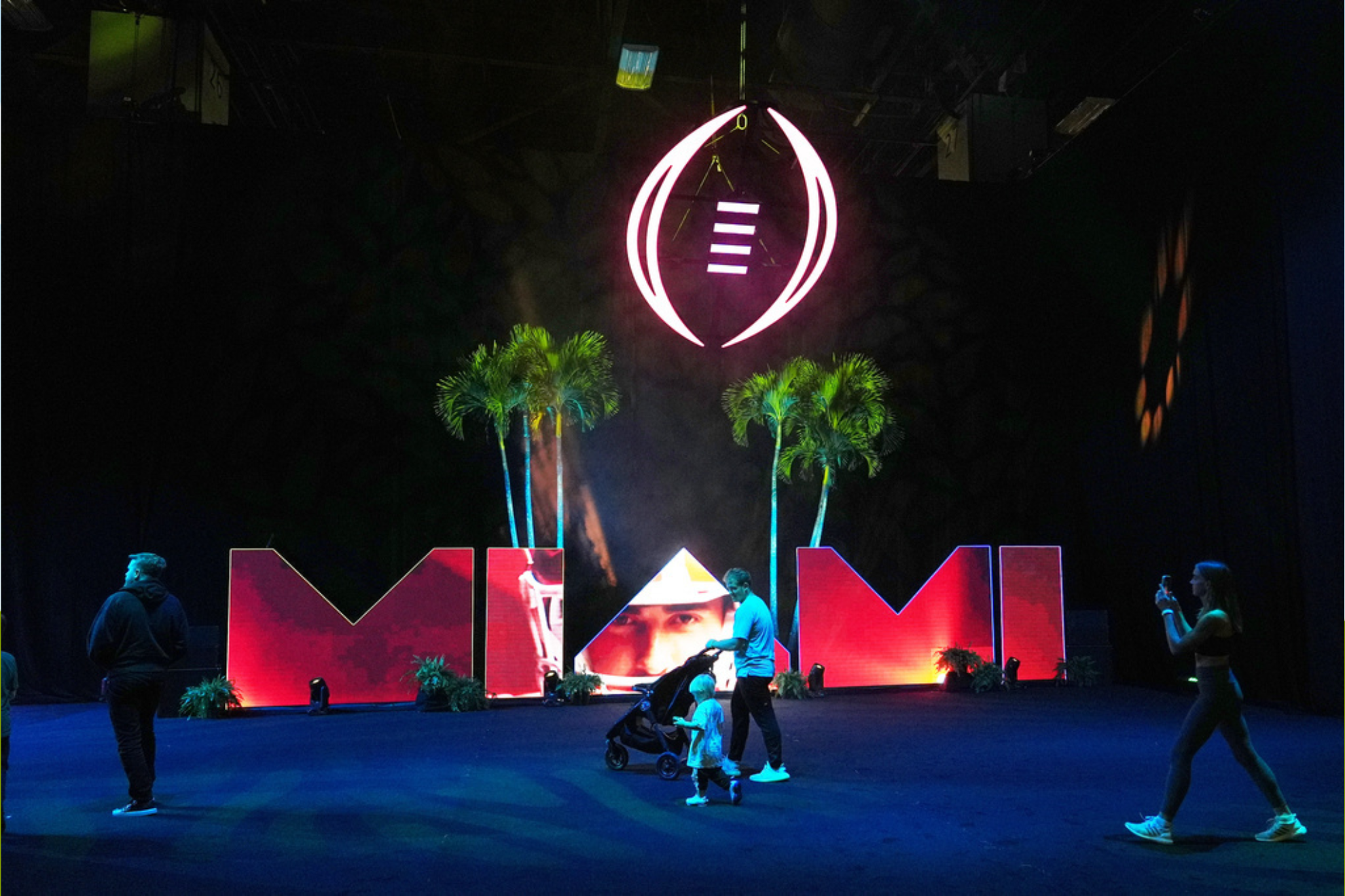 People walk past a display for Fan Fest for the NCAA College Football Playoff final between Miami and Indiana