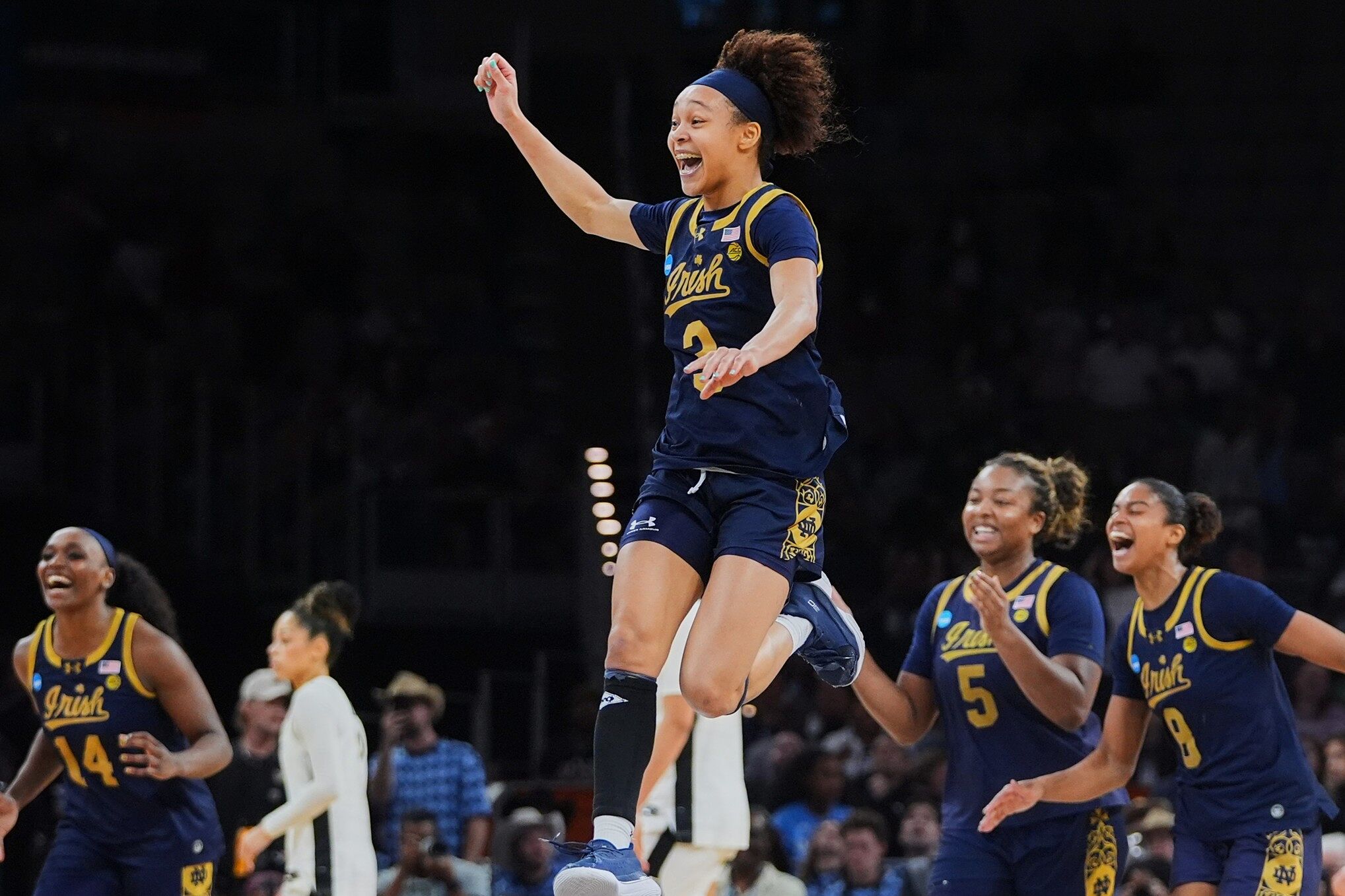 Notre Dame guard Hannah Hidalgo, top, and teammates celebrate the teams win against Vanderbilt in the Sweet 16 of the NCAA college basketball tournament