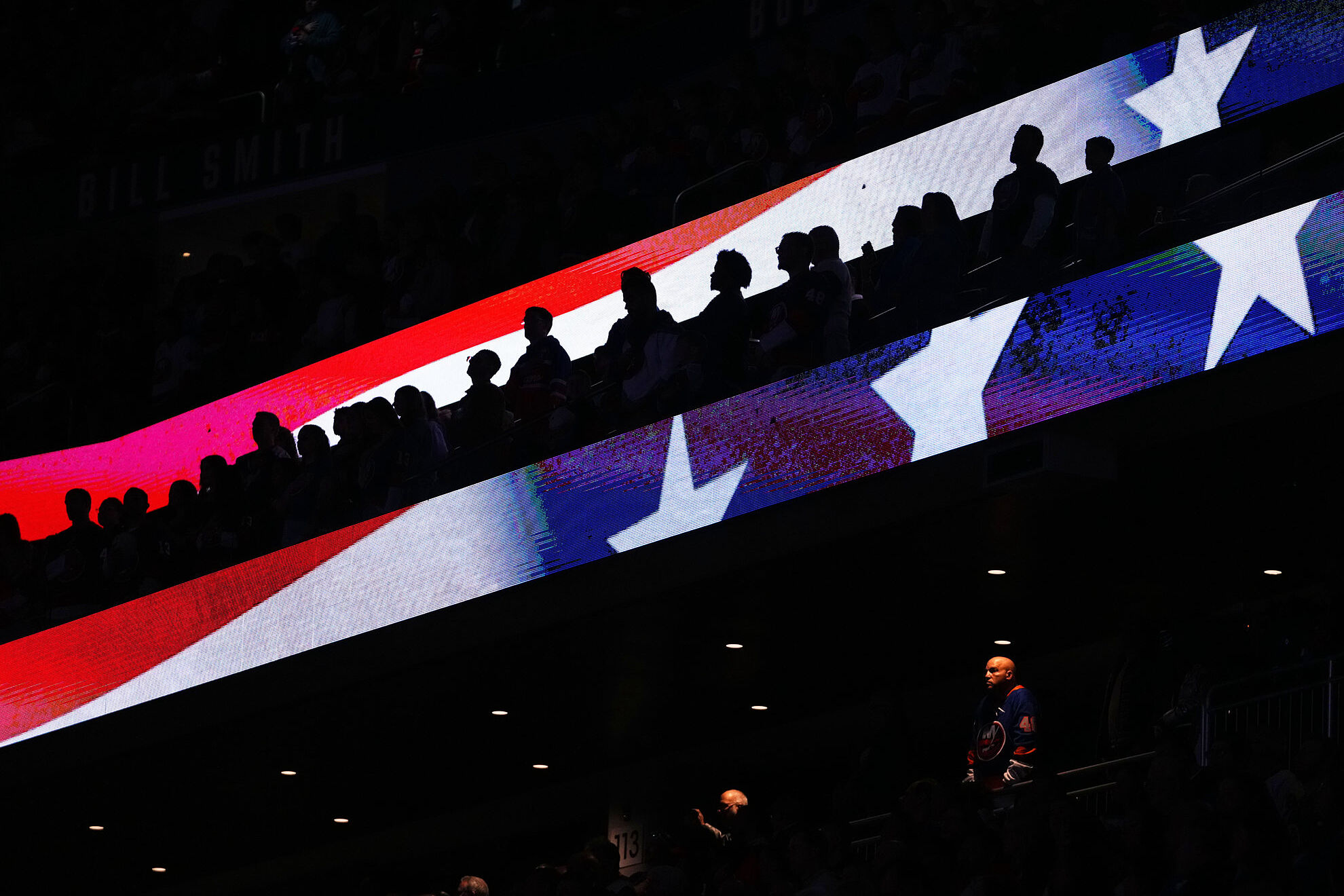 Fans stand during the playing of the national anthem at UBS Arena before an NHL hockey game