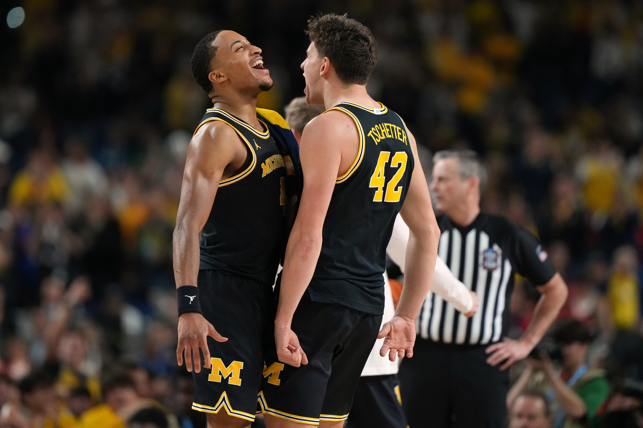 Michigan's Nimari Burnett, left, and Will Tschetter (42) celebrate during the second half of an NCAA college basketball tournament semifinal game against Arizona at the Final Four