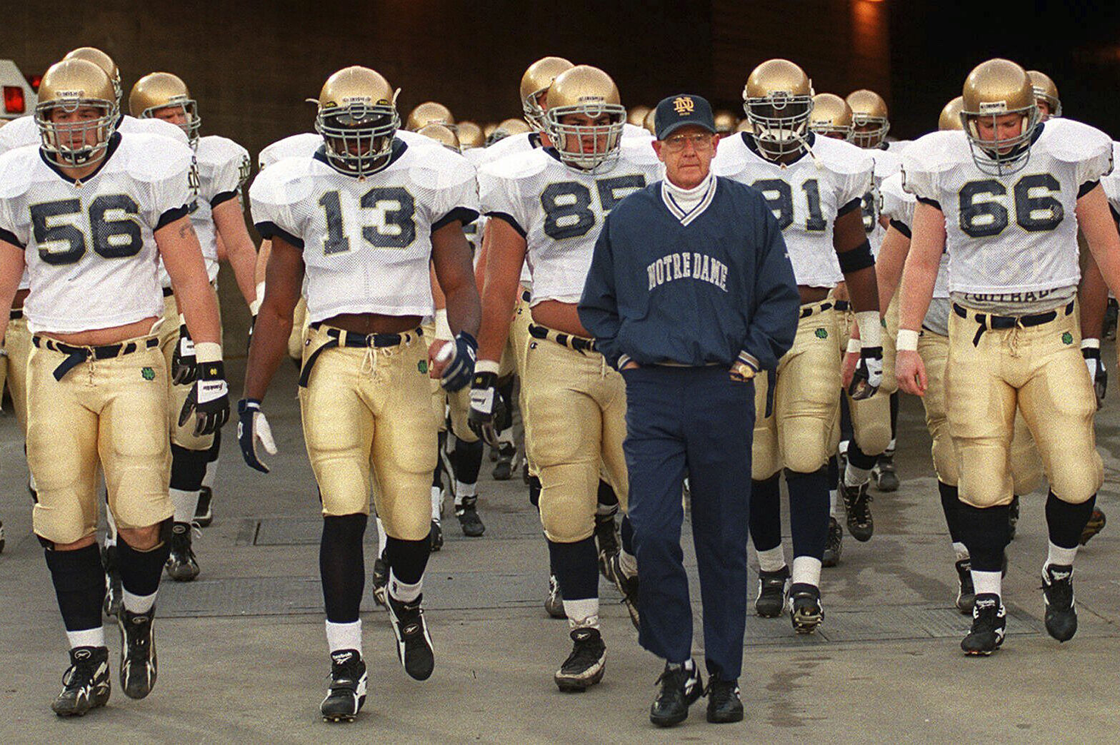 Notre Dame's head coach Lou Holtz and the Fighting Irish walk onto the field of the Los Angeles Coliseum to warm up for an NCAA college football game. (AP Photo/Kevork Djansezian, File)