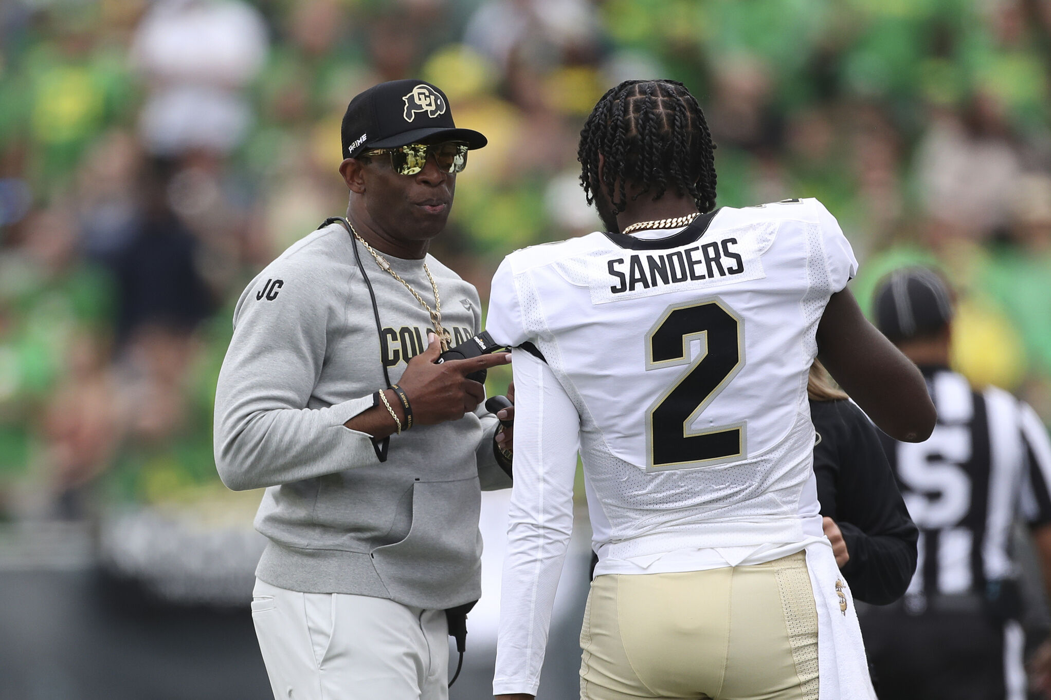 Colorado head coach Deion Sanders talks with his son and quarterback Shedeur Sanders