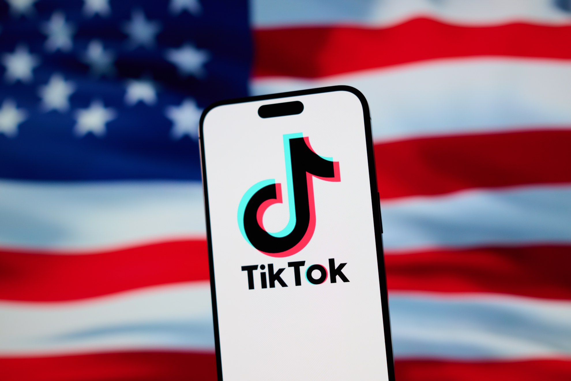 The TikTok logo with the US flag in the background.
