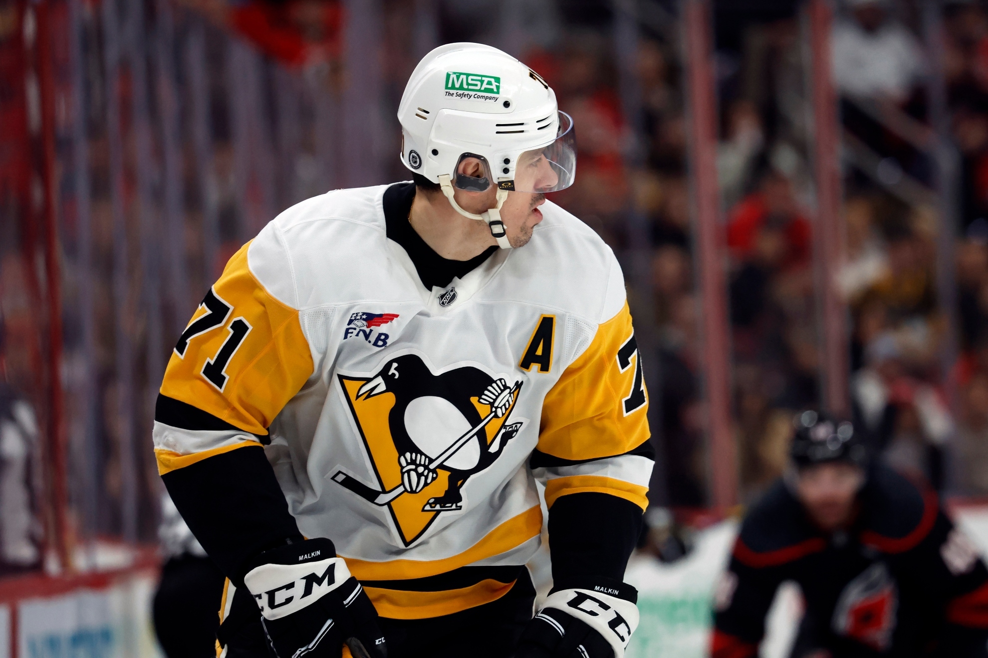 Evgeni Malkin watches the puck against the Carolina Hurricanes during an NHL game.