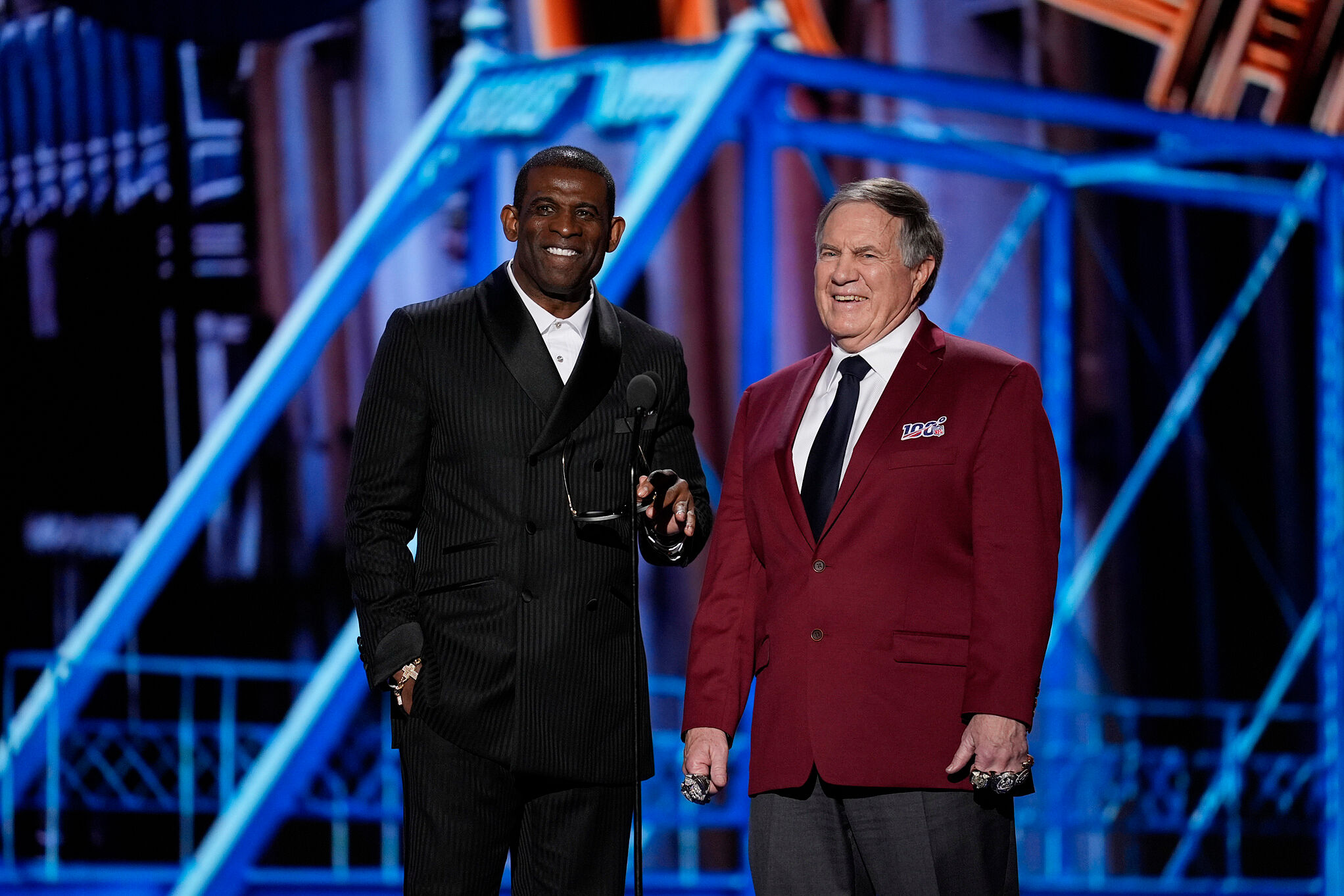 Coaches Deion Sanders, left, and Bill Belichick, right present the Coach of the year award during the NFL Honors