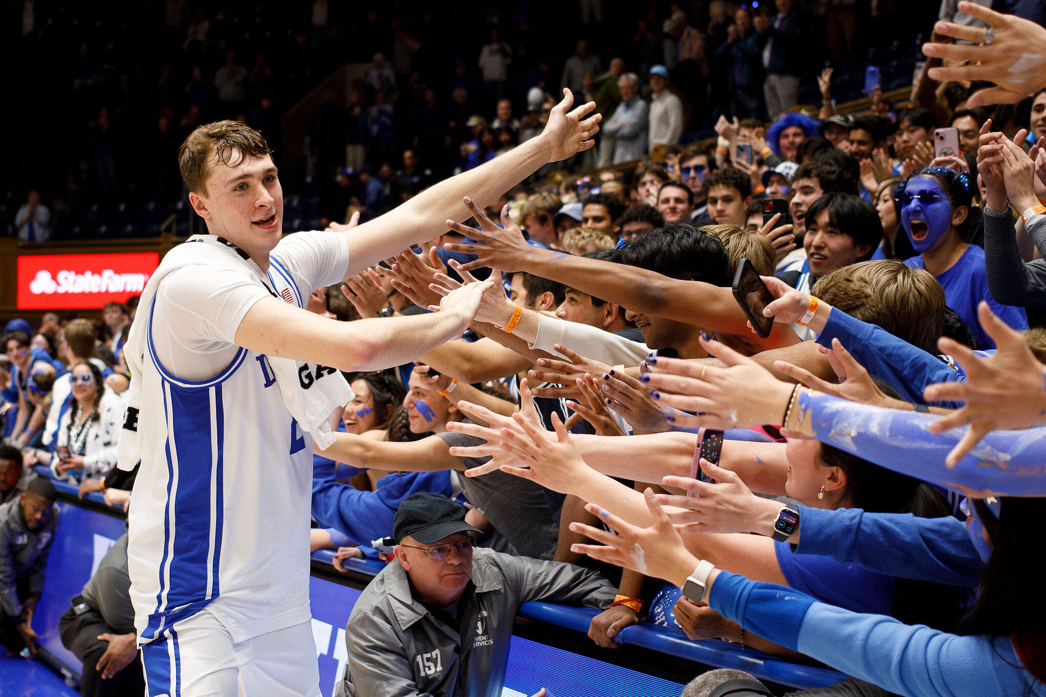 Duke's Cooper Flagg, left, high-fives fans as he leaves the court after an NCAA college basketball game
