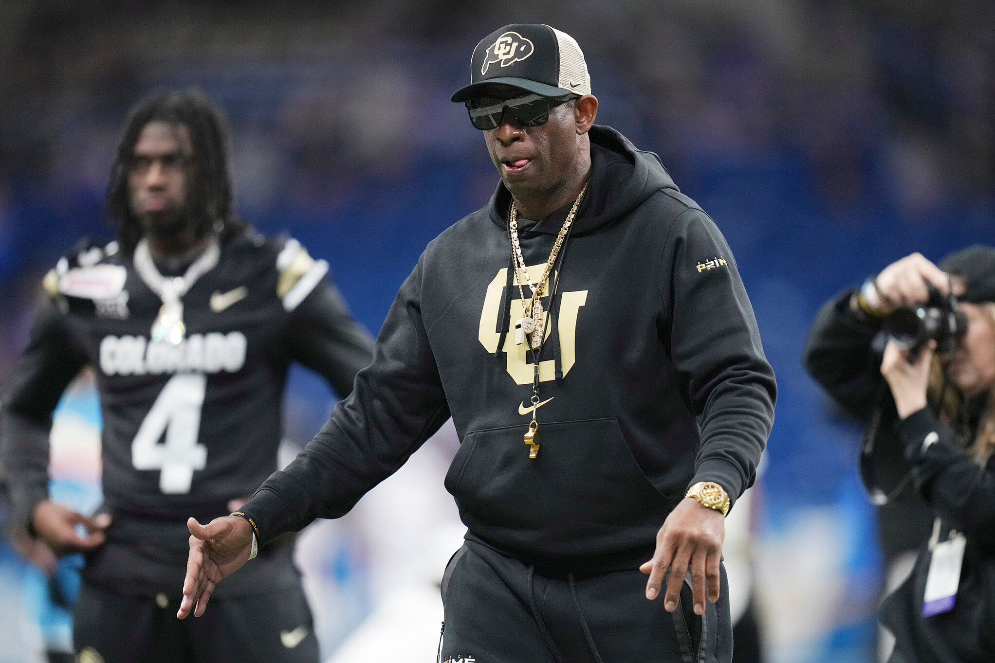 Colorado head coach Deion Sanders watches his players warm up for the Alamo Bow against BYU