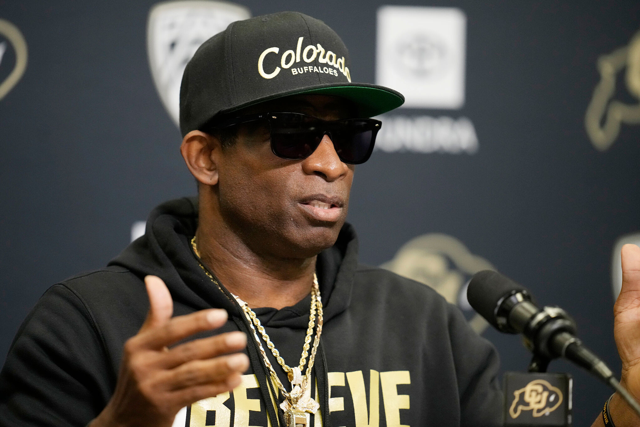 Colorado head coach Deion Sanders responds to questions during a news conference