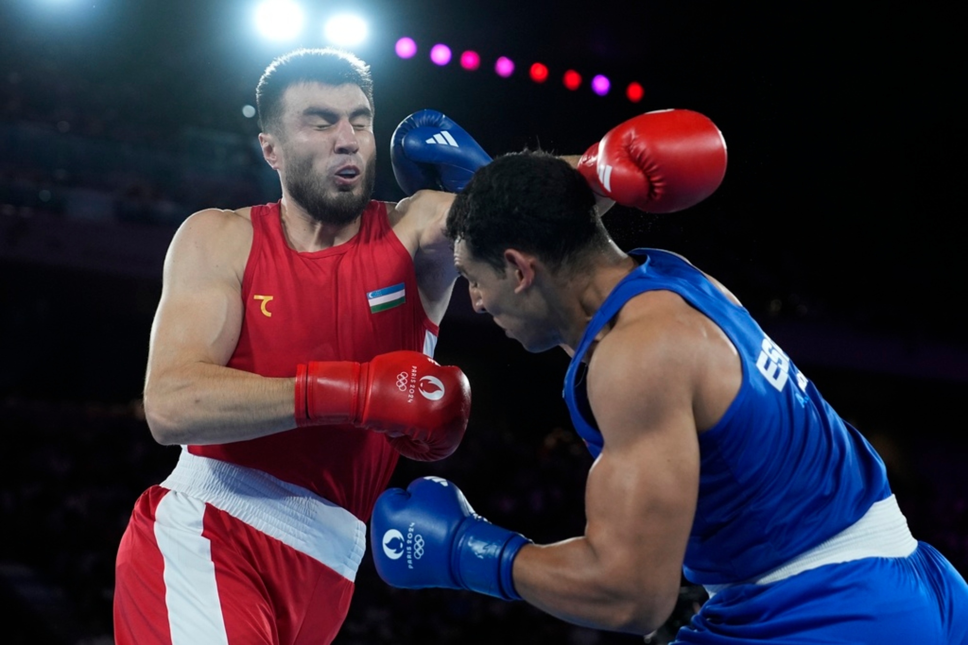Uzbekistan's Bakhodir Jalolov, left, fights Spain's Ayoub Ghadfa in their men's +92 kg final boxing match at the 2024 Summer Olympics.