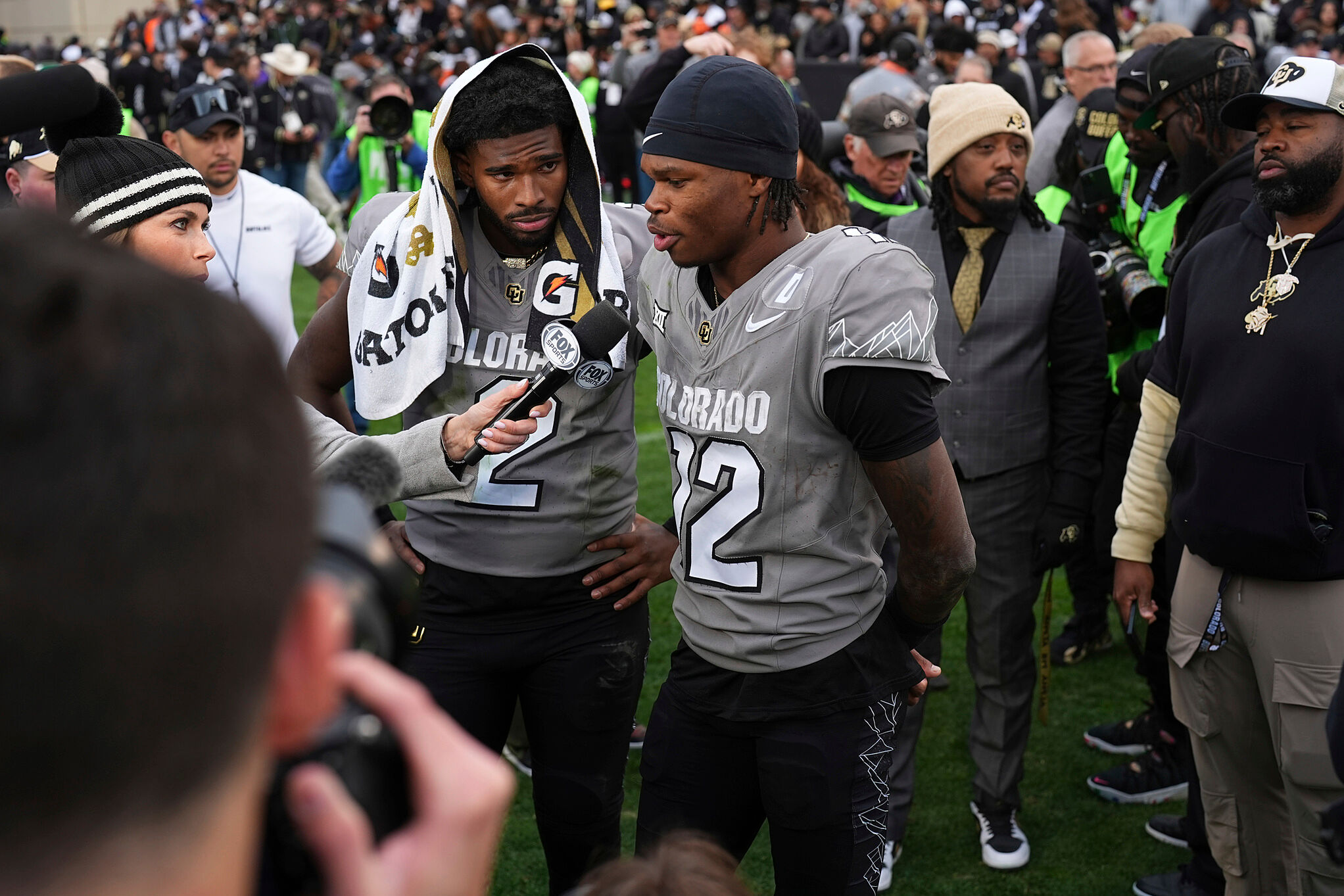 Colorado's WR Travis Hunter (12) answers a question during a interview as Colorado QB Shedeur Sanders (2) listens