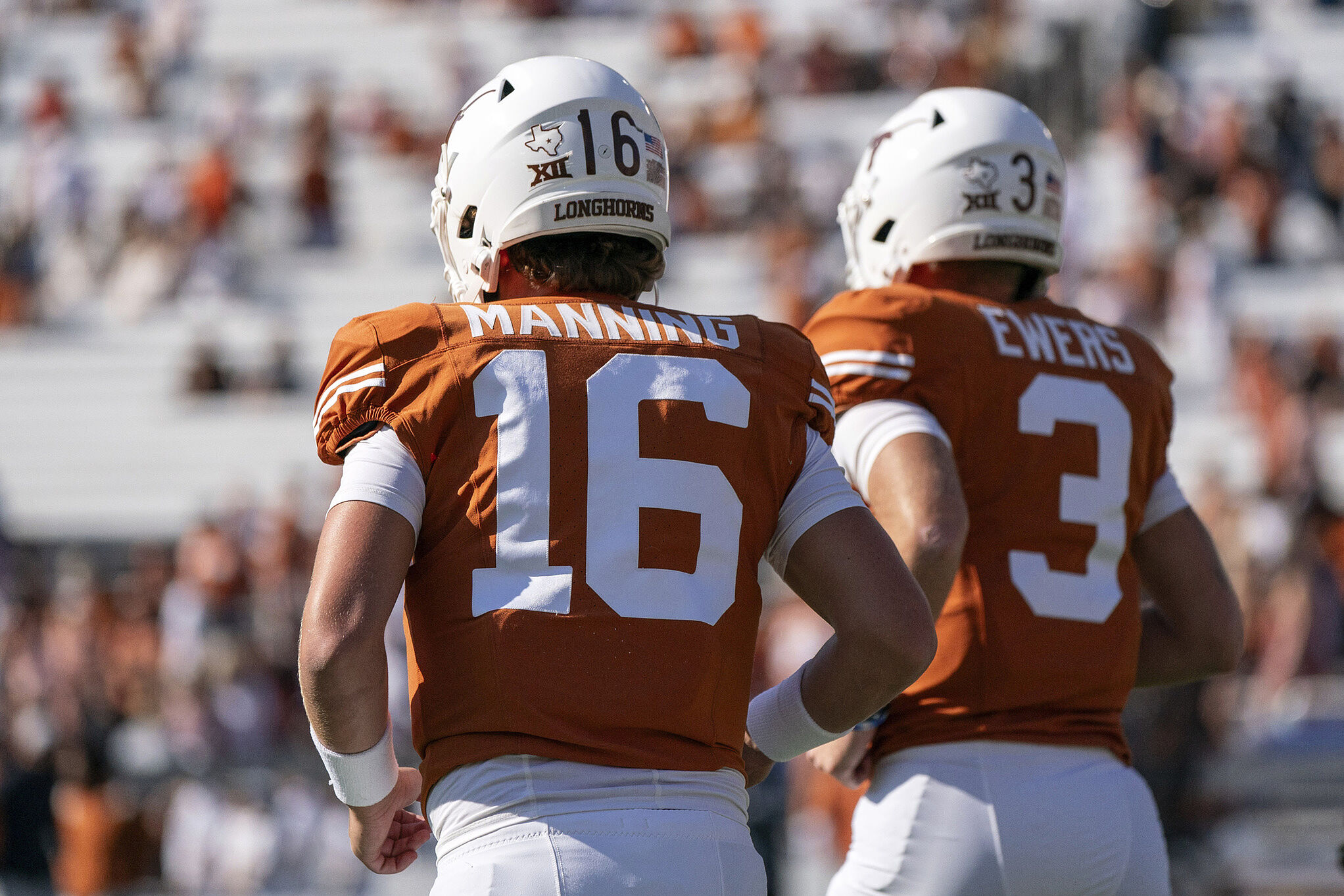 Texas quarterbacks Arch Manning (16) and Quinn Ewers (3) run off the field before an NCAA college football game against Oklahoma at the Cotton Bowl