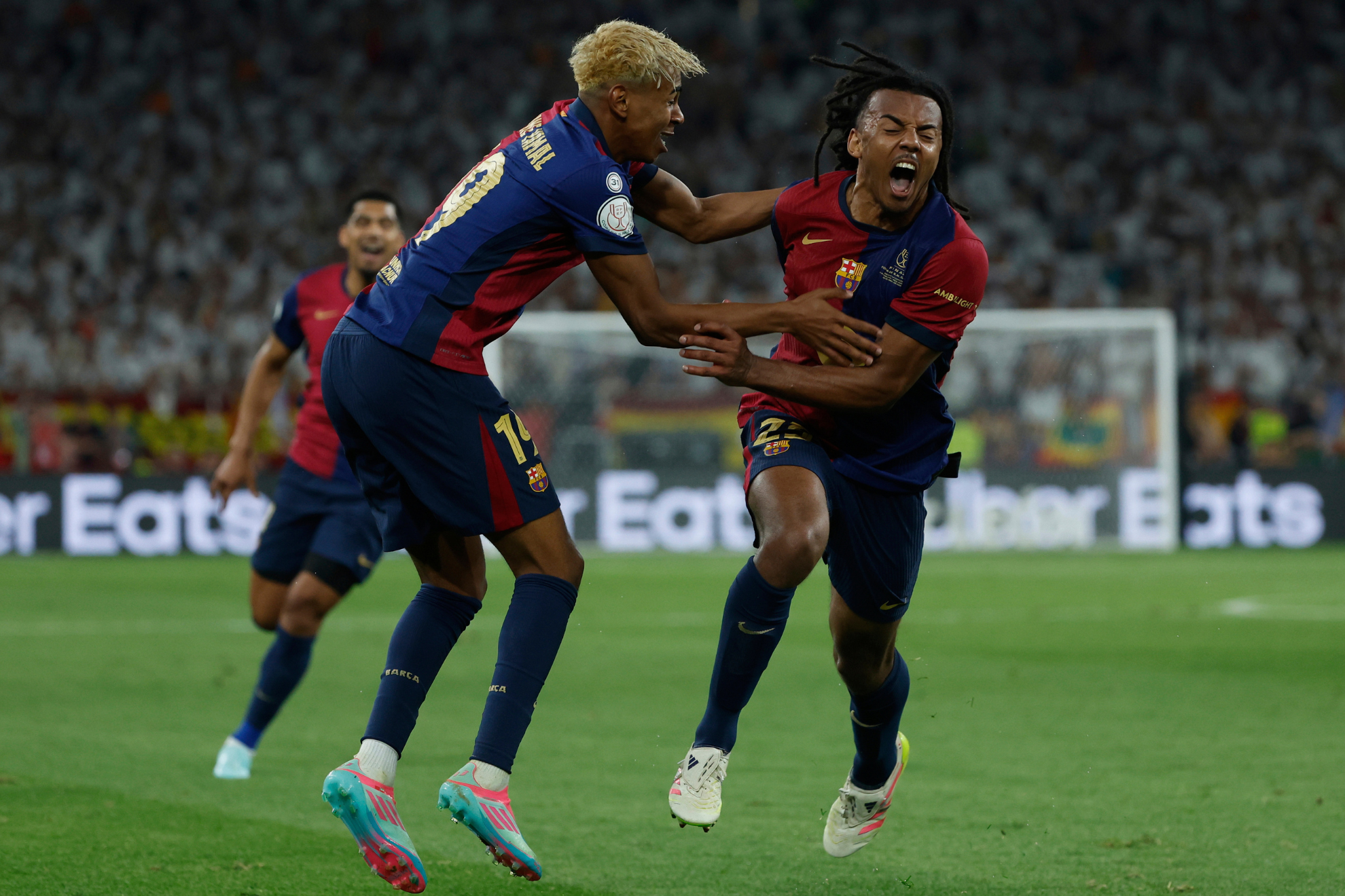Jules Kounde and Lamine Yamal celebrate Barcelona's trophy-winning goal.