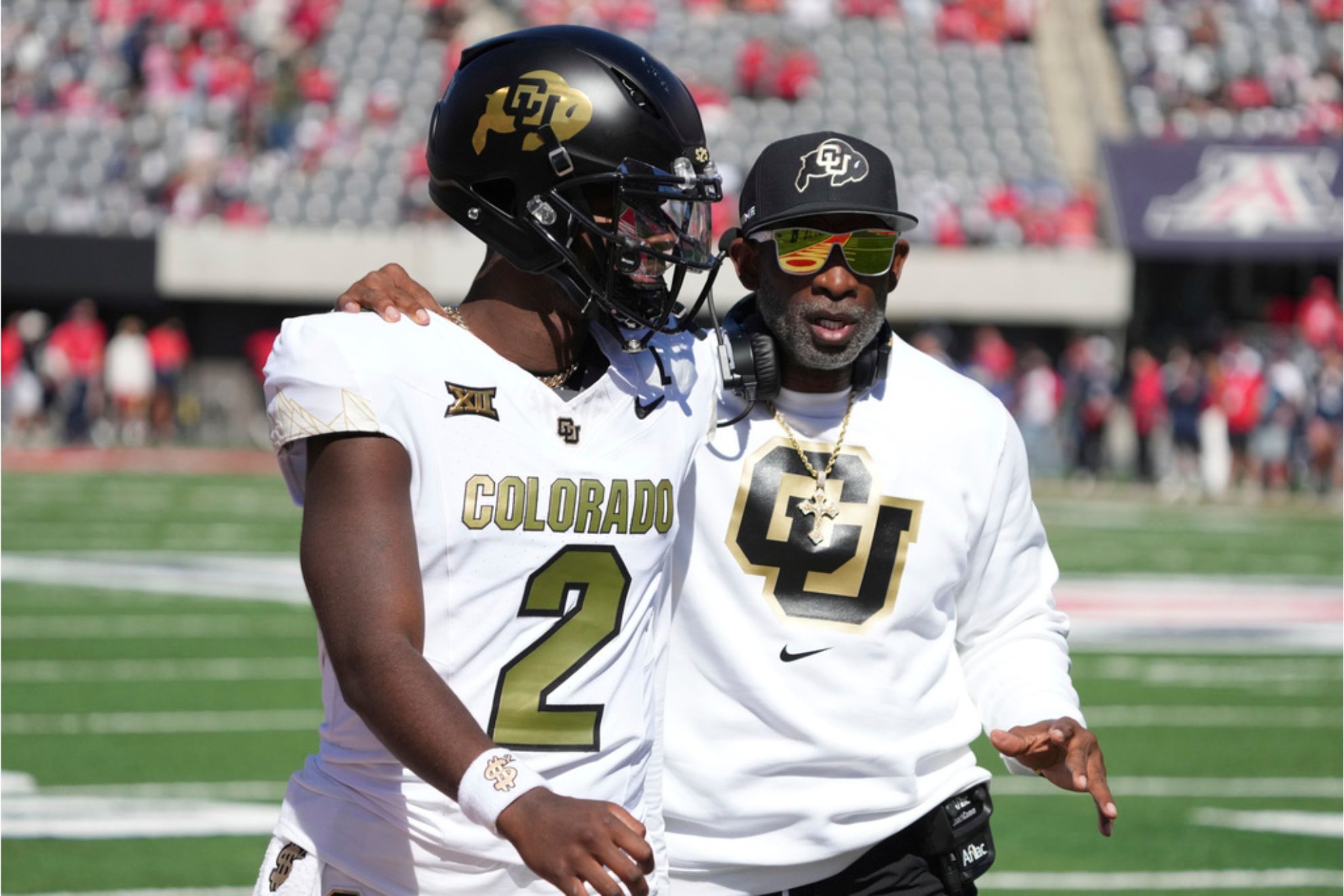 Colorado head coach Deion Sanders talks to quarterback Shedeur Sanders in the first half during an NCAA college football game against Arizona